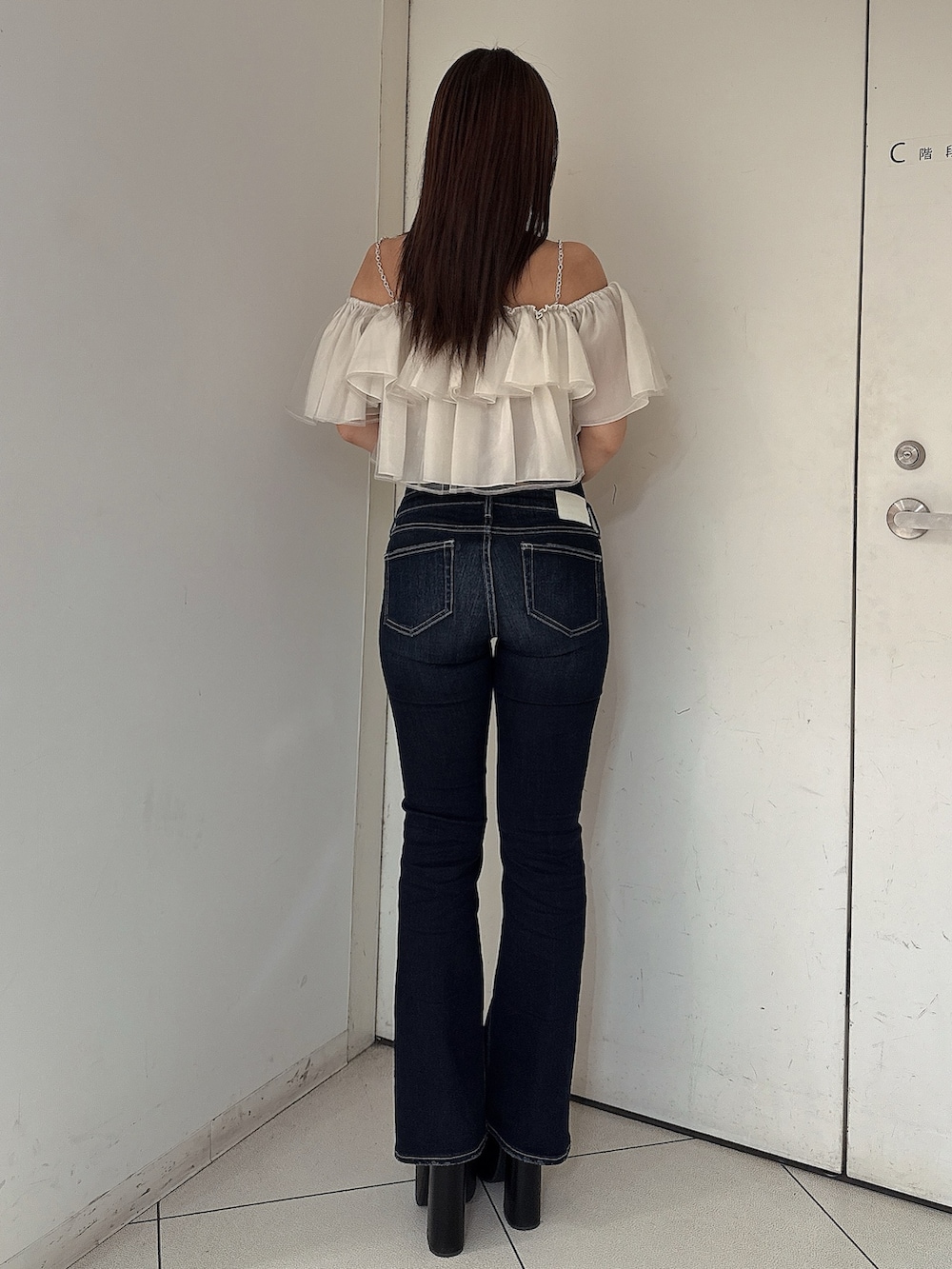 ブルー系のデニムパンツ、ブラック系のサンダル、ベージュ系のシャツ/ブラウスを着用したレディースの夏コーディネートの3枚目の写真