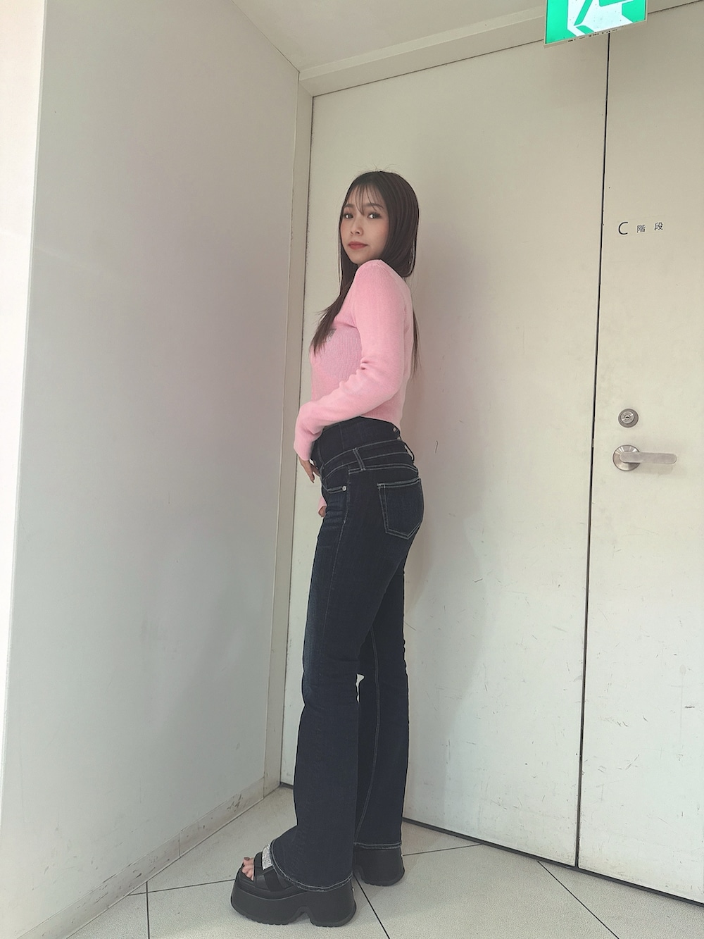 ブルー系のデニムパンツ、ブラック系のサンダル、ピンク系のニット/セーターを着用したレディースの春コーディネートの2枚目の写真