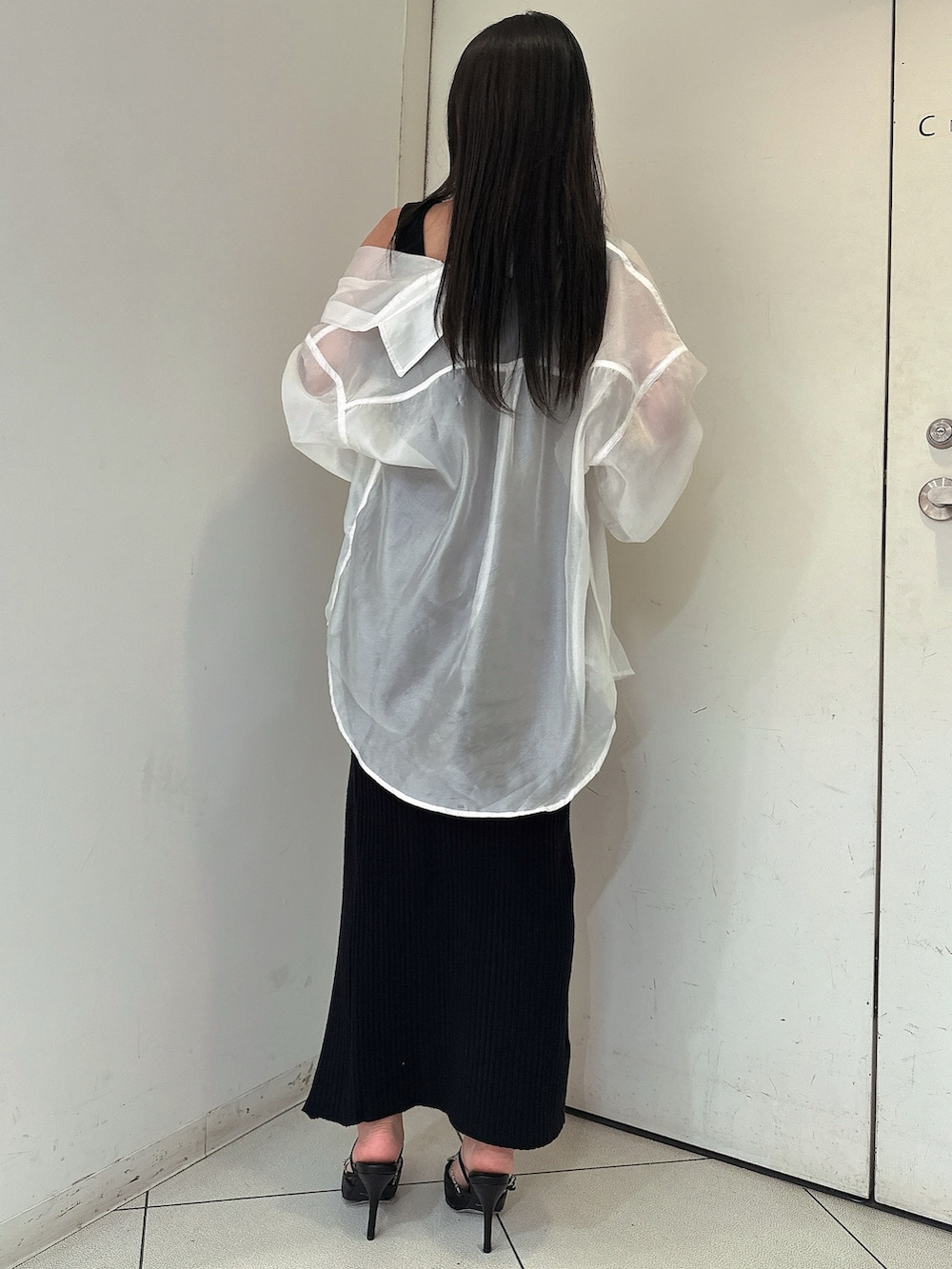 ホワイト系のシャツ/ブラウス、ブラック系のワンピース、ブラック系のパンプスを着用したレディースの春コーディネートの3枚目の写真