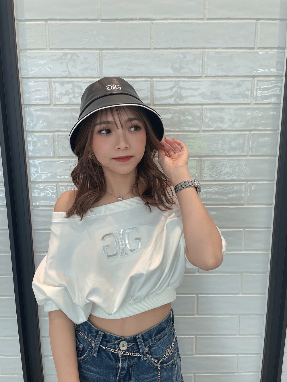 ブルー系のデニムパンツ、ブラック系のハンドバッグ、ブラック系のサンダルを着用したレディースの春コーディネートの3枚目の写真