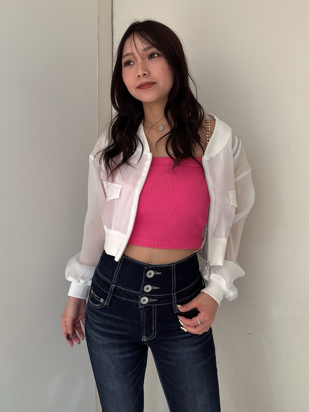 ブルー系のデニムパンツ、ホワイト系のブルゾン、ピンク系のキャミソールを着用したレディースの春コーディネートの4枚目の写真