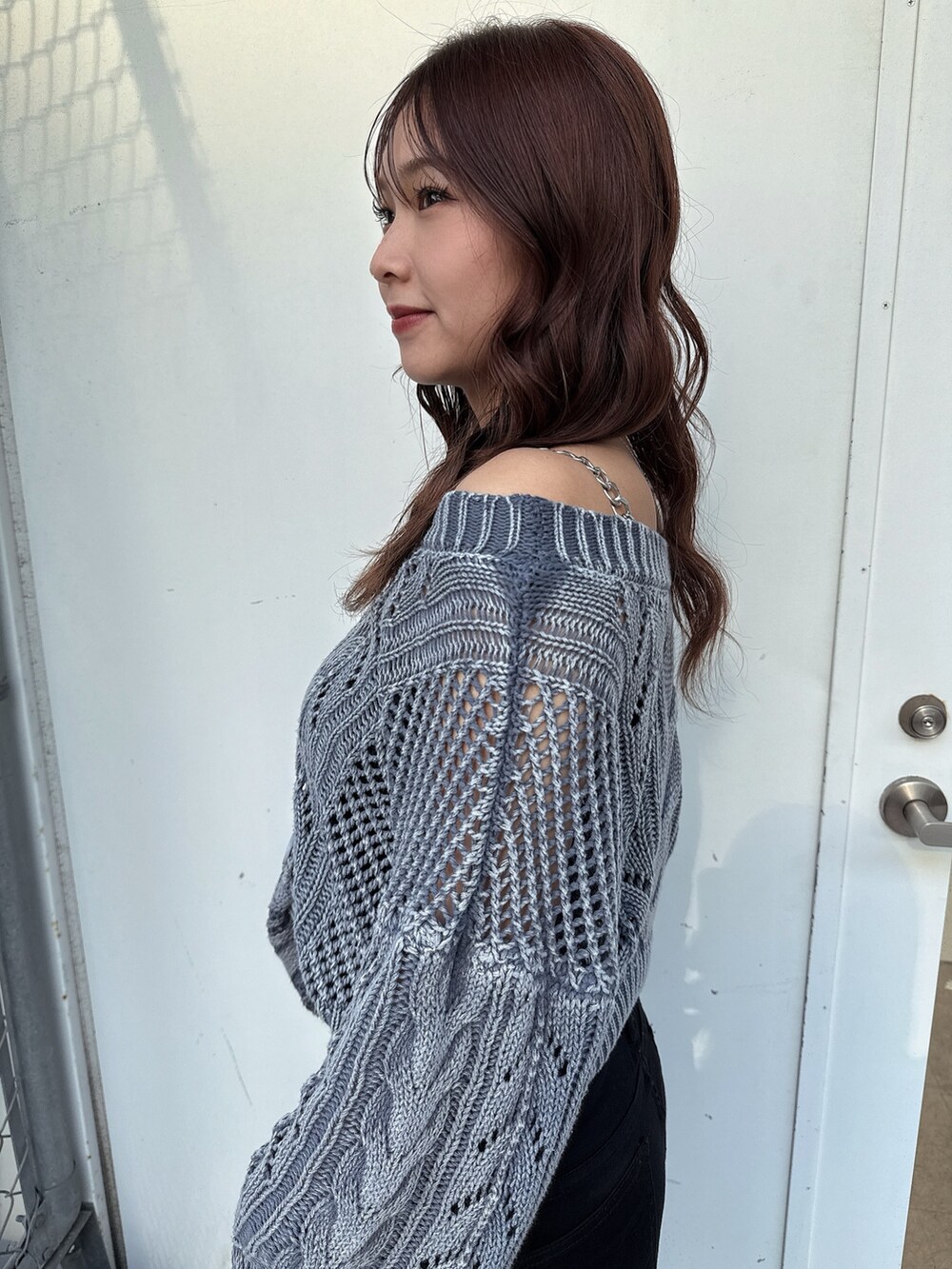 ブルー系のニット/セーター、ブラック系のデニムパンツ、ホワイト系のパンプスを着用したレディースの春コーディネートの5枚目の写真