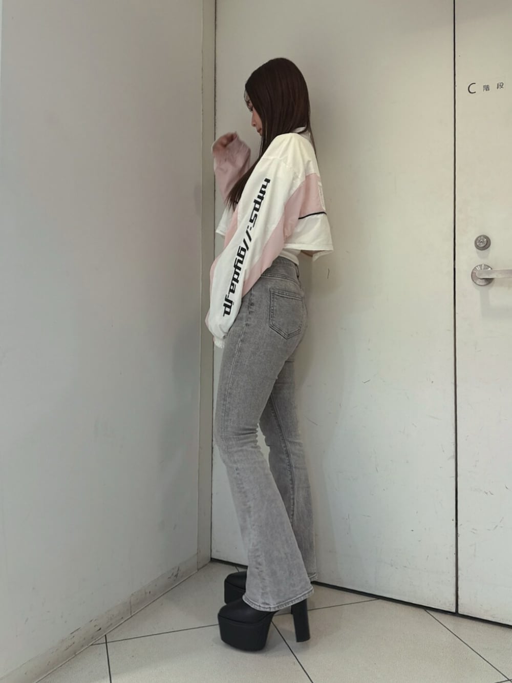 グレー系のデニムパンツ、ホワイト系のTシャツ/カットソー、ブラック系のブーツを着用したレディースの夏コーディネートの2枚目の写真