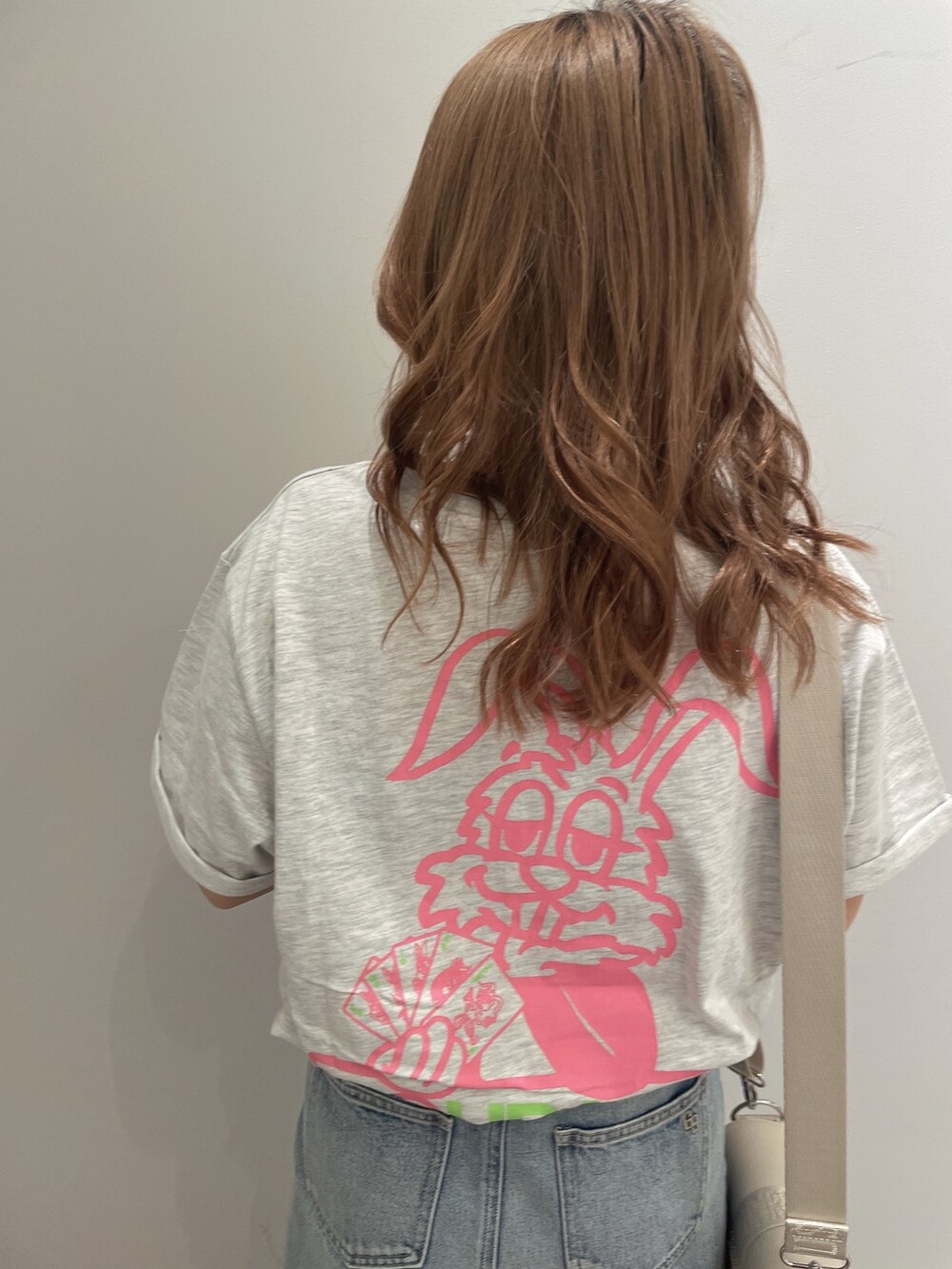 ホワイト系のTシャツ/カットソー、ブルー系のデニムスカート、ホワイト系のサンダルを着用したレディースの春コーディネートの6枚目の写真