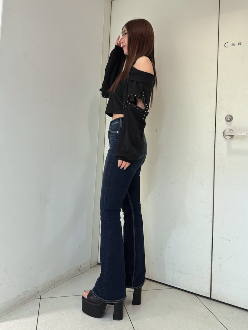 ブルー系のデニムパンツ、ブラック系のサンダル、ブラック系のTシャツ/カットソーを着用したレディースの春コーディネートの2枚目の写真