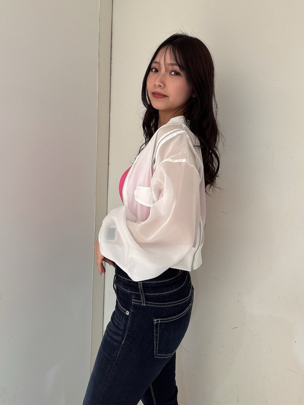 ブルー系のデニムパンツ、ホワイト系のブルゾン、ピンク系のキャミソールを着用したレディースの春コーディネートの5枚目の写真