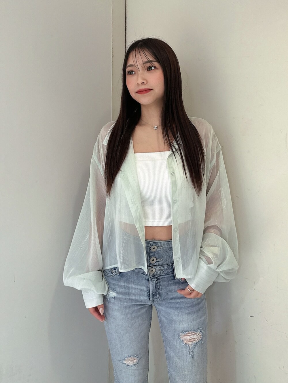 ブルー系のデニムパンツ、グリーン系のシャツ/ブラウス、ホワイト系のチューブトップを着用したレディースの春コーディネートの4枚目の写真