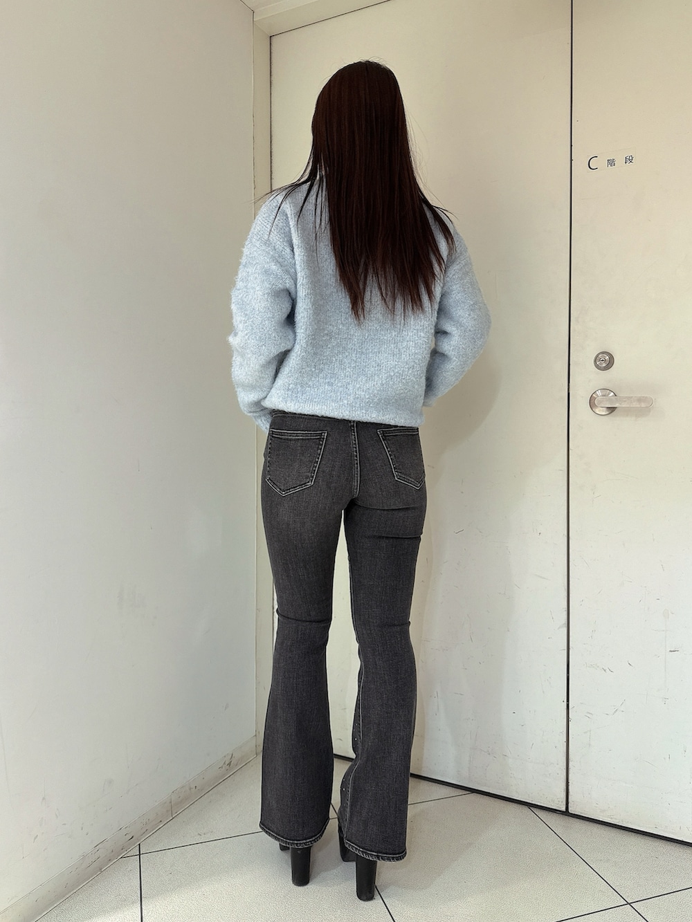 ブラック系のブーツ、ブルー系のニット/セーター、ブラック系のデニムパンツを着用したレディースの冬コーディネートの3枚目の写真