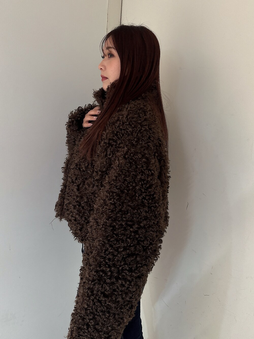 ブルー系のデニムパンツ、ブラック系のブーツ、ブラウン系のブルゾンを着用したレディースの秋コーディネートの5枚目の写真