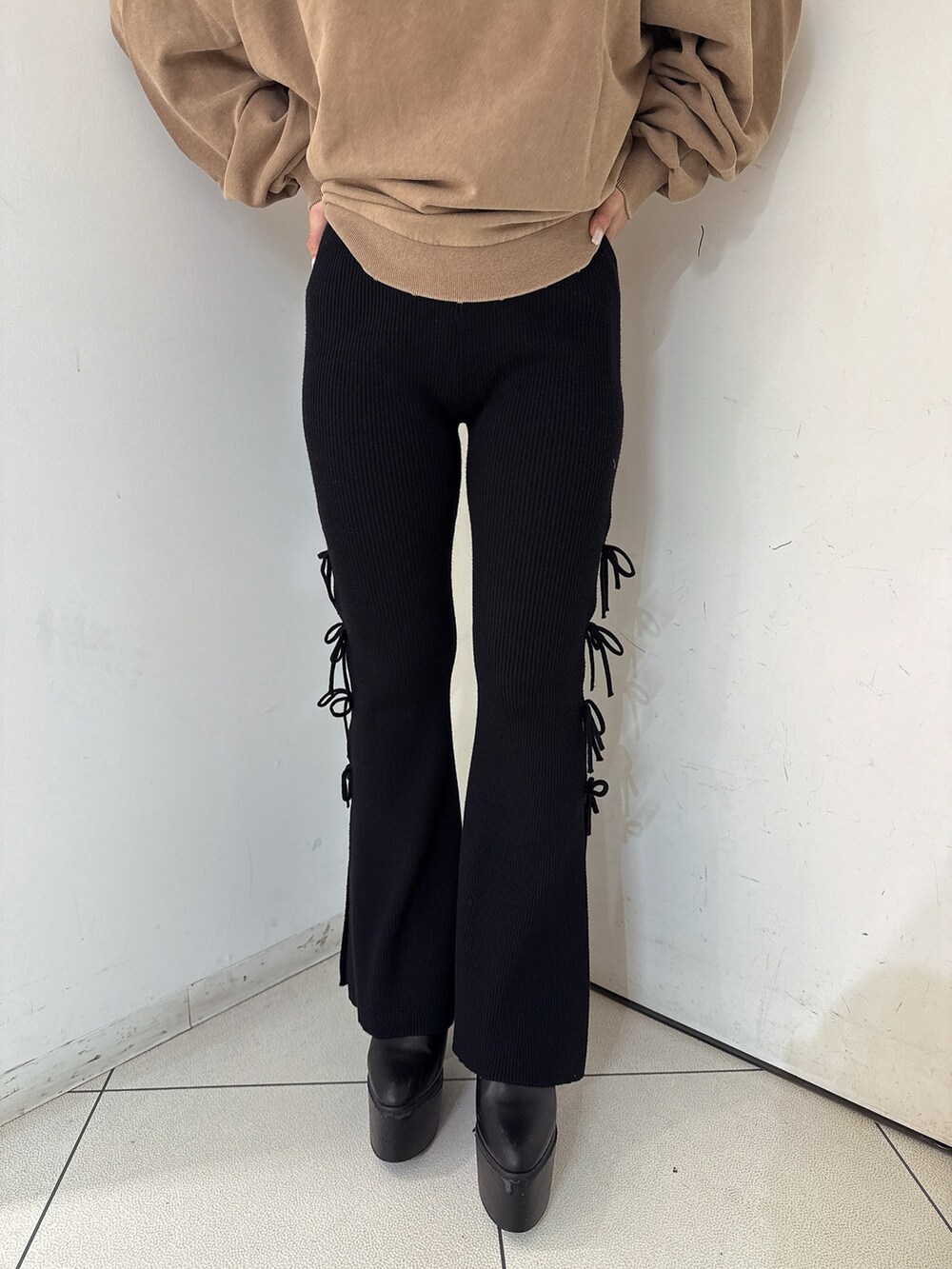 イエロー系のスウェット、ブラック系のその他パンツ、ブラック系のブーツを着用したレディースの秋コーディネートの8枚目の写真