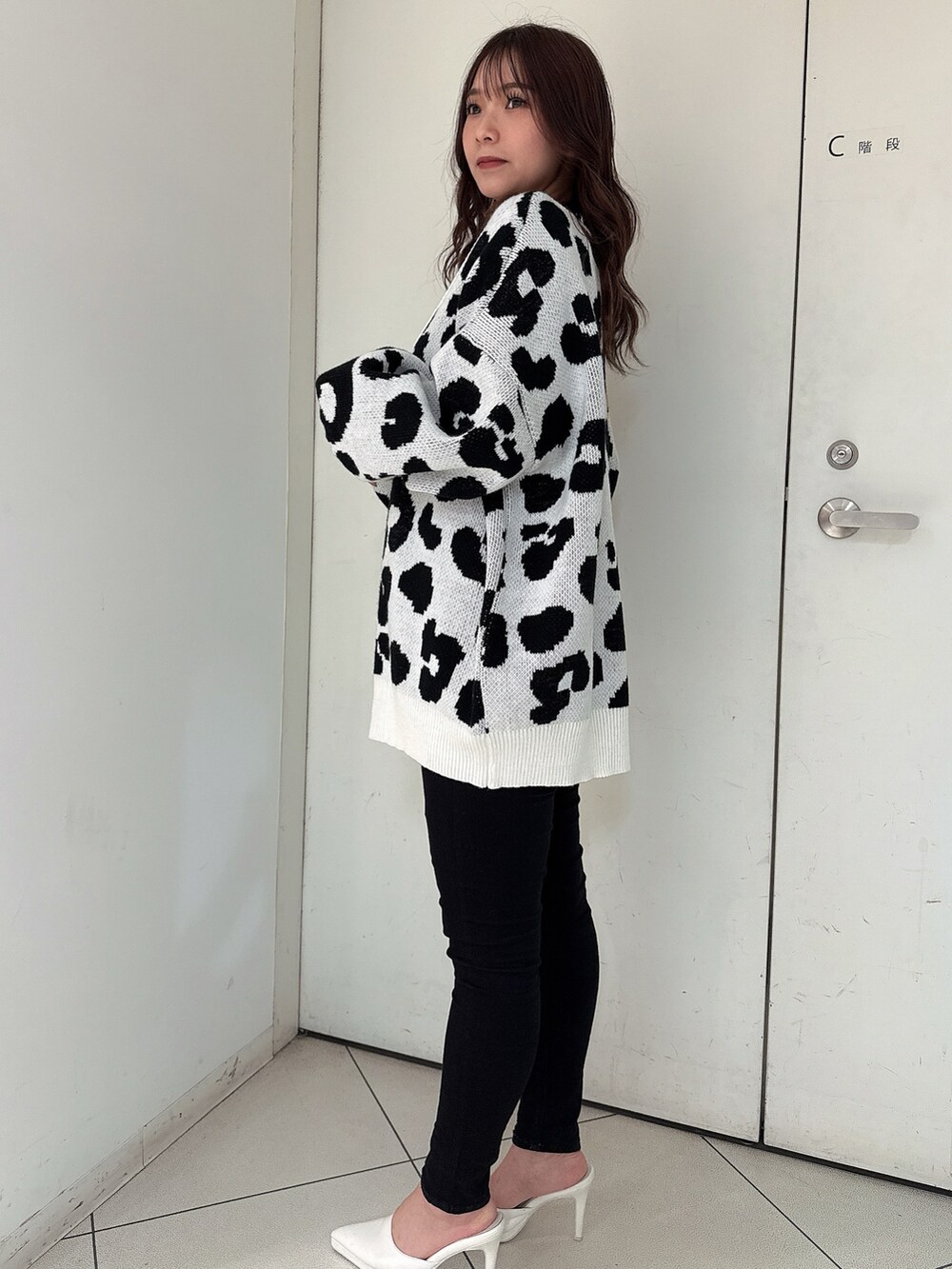 ホワイト系のカーディガン/ボレロ、ブラック系のキャミソール、ブラック系のデニムパンツを着用したレディースの春コーディネートの2枚目の写真