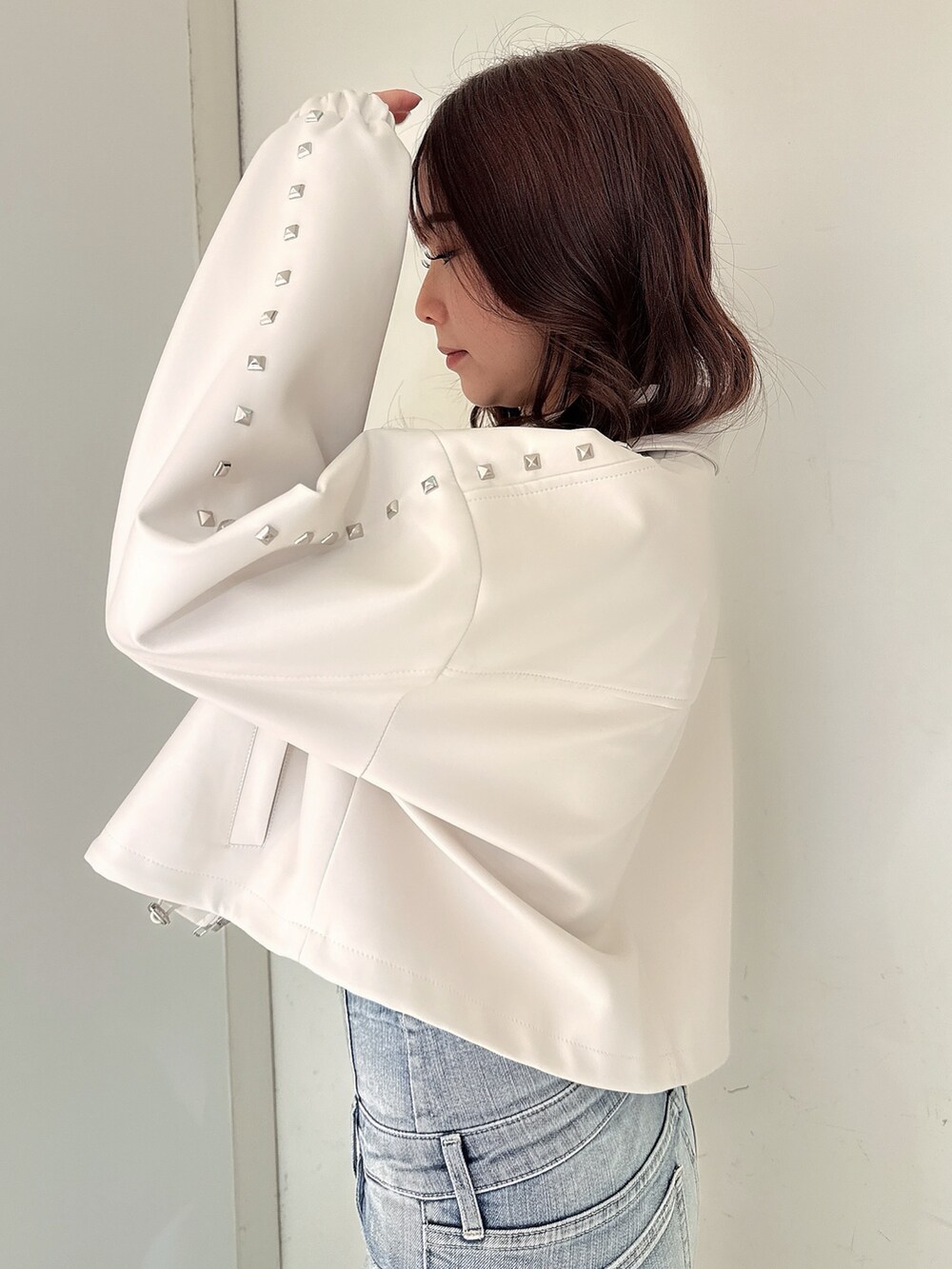 ホワイト系のパンプス、ブルー系のデニムパンツ、ホワイト系のキャミソールを着用したレディースの春コーディネートの5枚目の写真