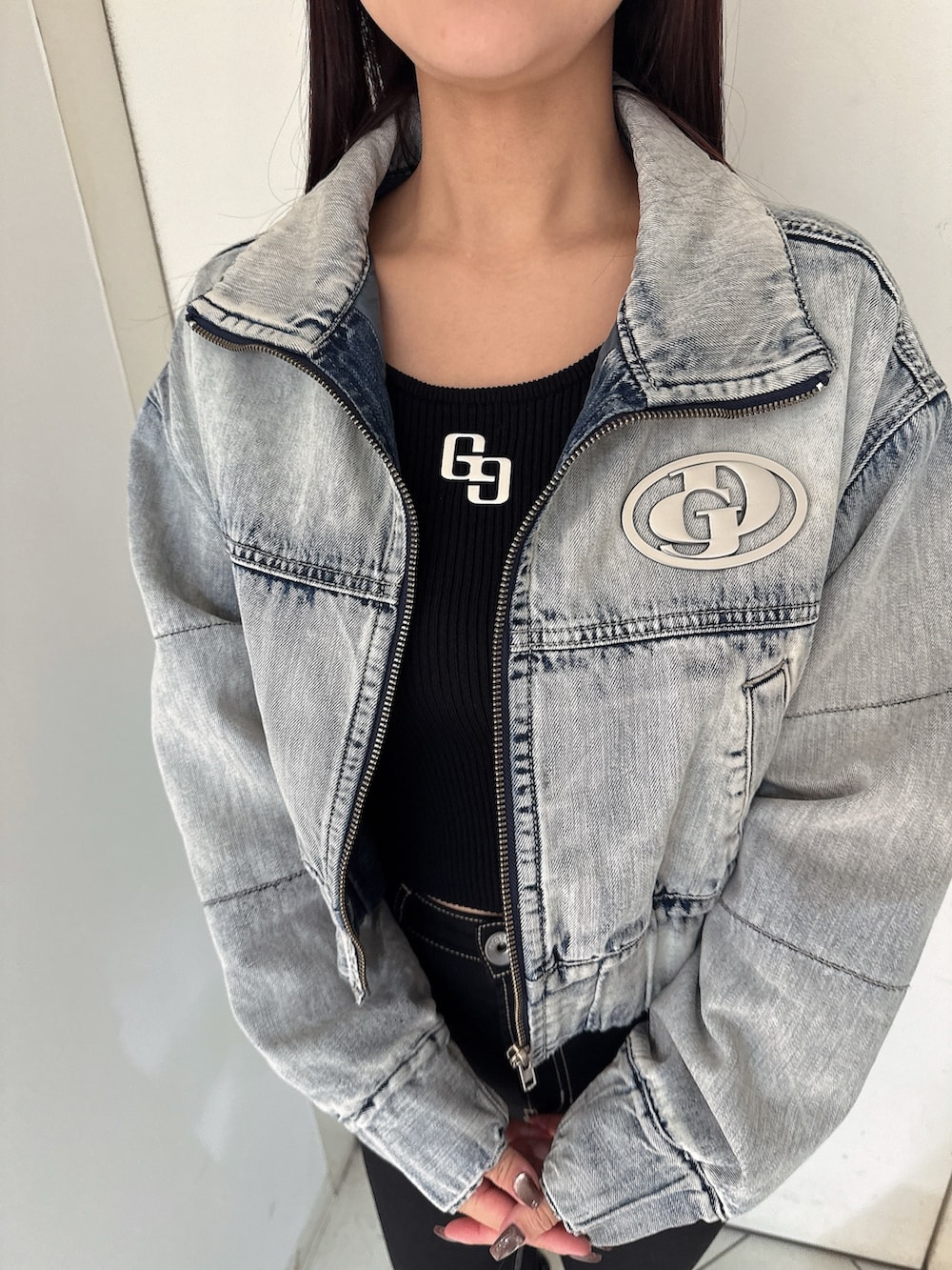 ブラック系のニット/セーター、ブラック系のデニムパンツ、ブラック系のブーツを着用したレディースの秋コーディネートの7枚目の写真