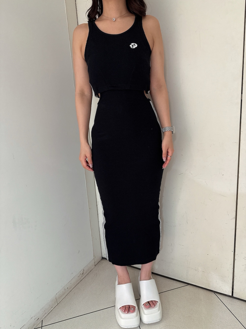 ブラック系のワンピース、ホワイト系のサンダルを着用したレディースの夏コーディネートの7枚目の写真