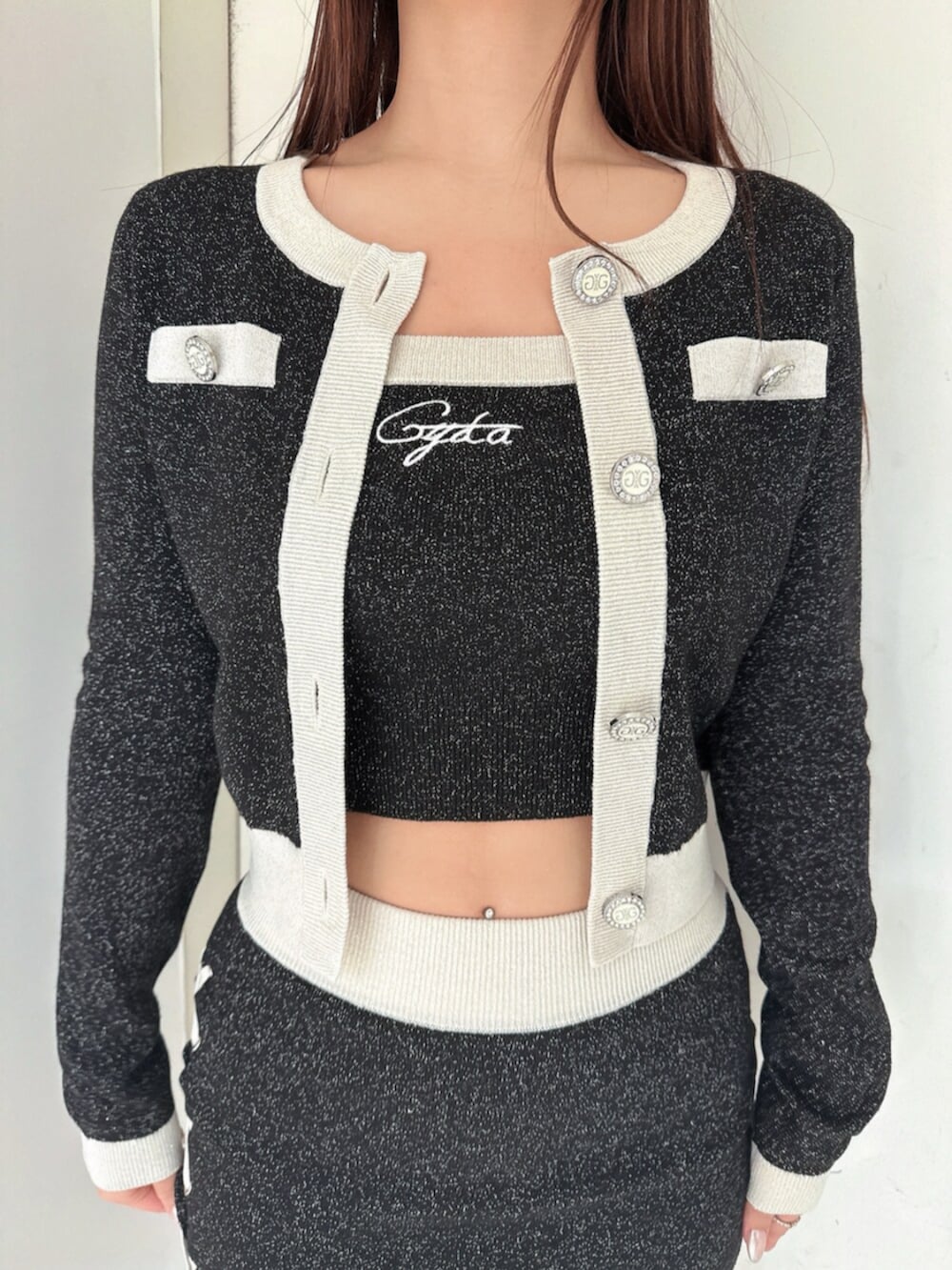 ブラック系のニット/セーター、ブラック系のスカート、ブラック系のブーツを着用したレディースの春コーディネートの7枚目の写真