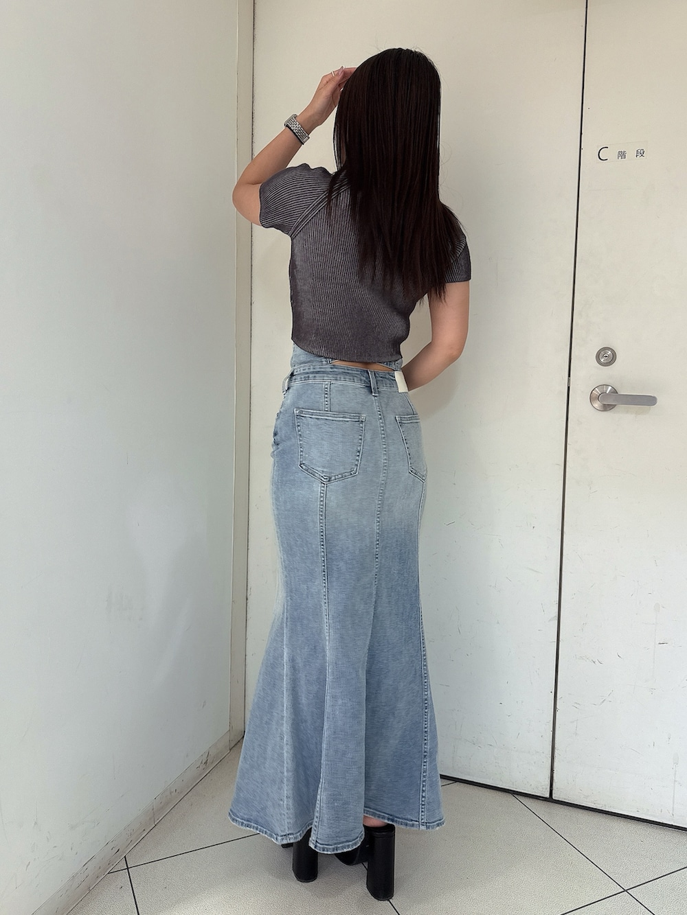 ホワイト系のニット/セーター、ブルー系のデニムスカート、ホワイト系のサンダルを着用したレディースの夏コーディネートの3枚目の写真