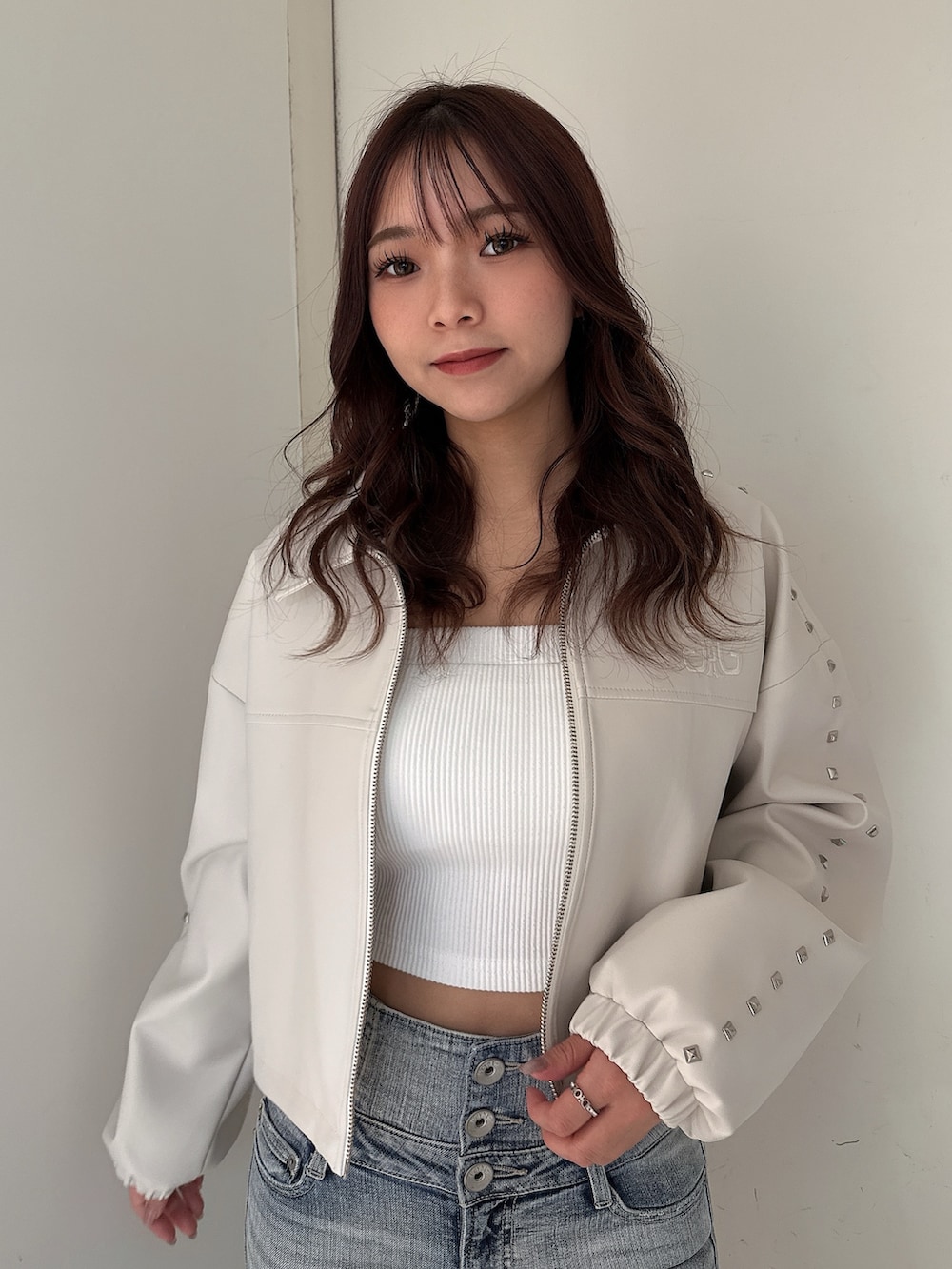 ホワイト系のパンプス、ブルー系のデニムパンツ、ホワイト系のキャミソールを着用したレディースの春コーディネートの4枚目の写真