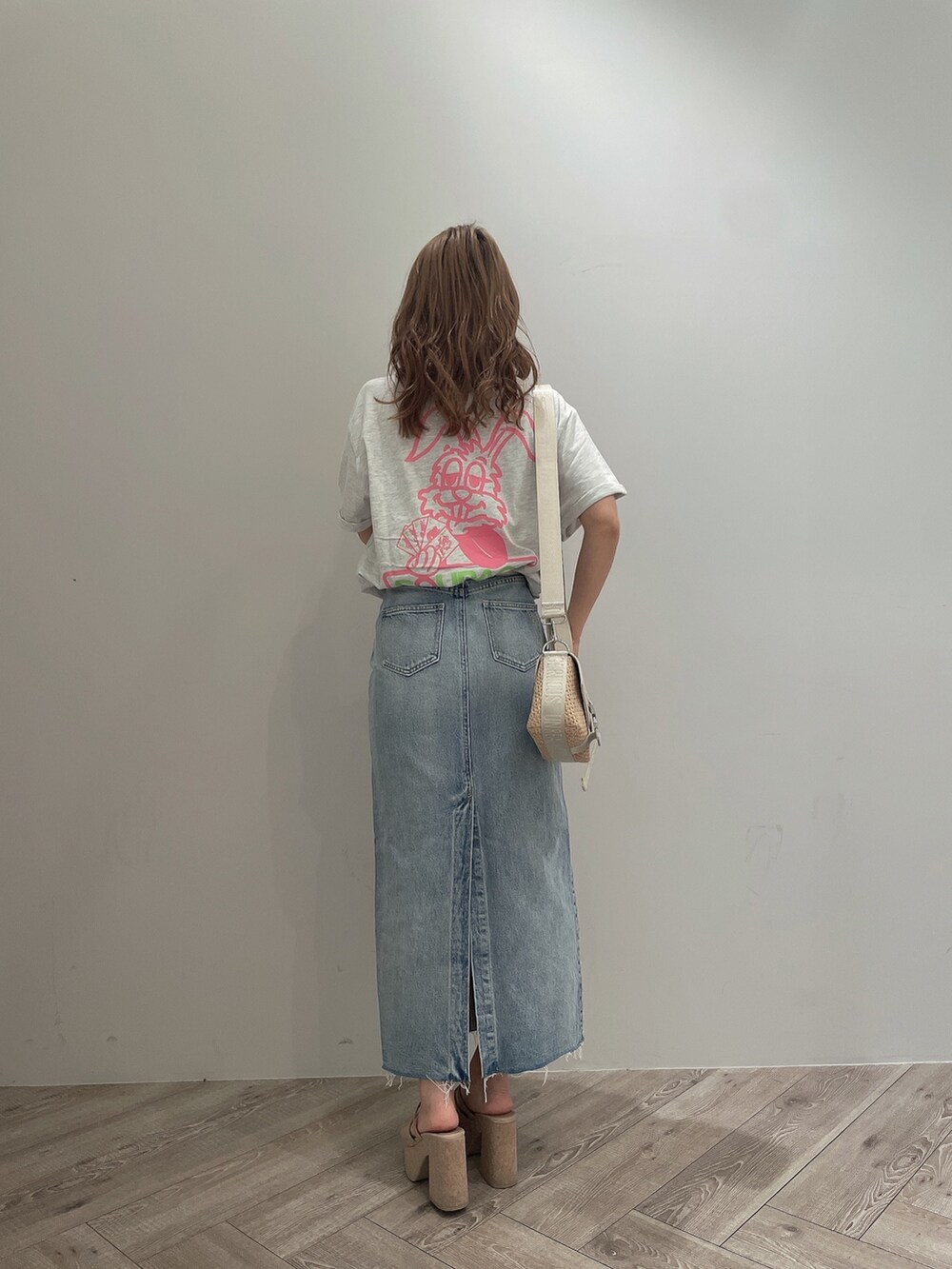 ホワイト系のTシャツ/カットソー、ブルー系のデニムスカート、ホワイト系のサンダルを着用したレディースの春コーディネートの4枚目の写真