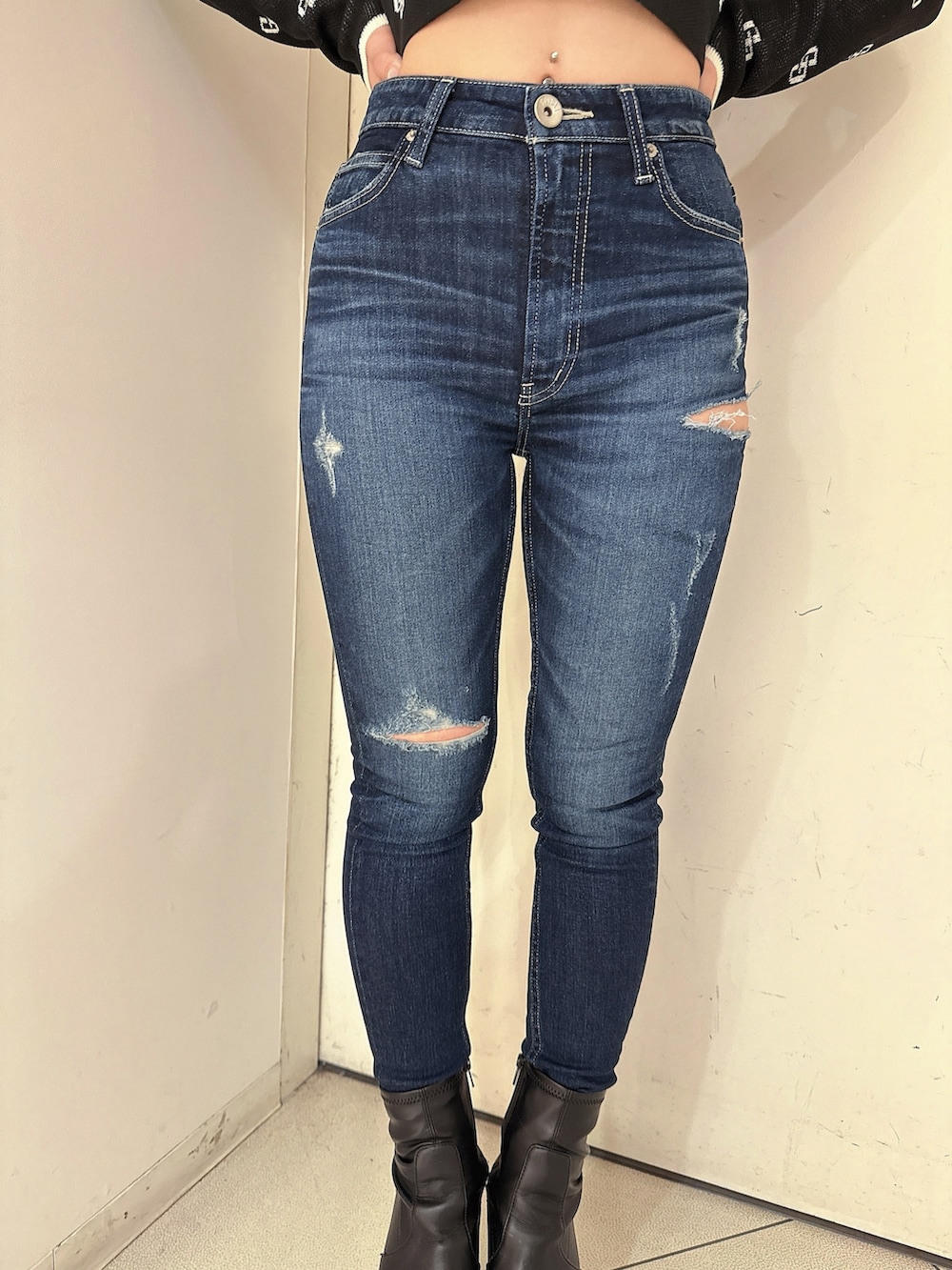 ブラック系のブーツ、ブルー系のデニムパンツ、ブラック系のニット/セーターを着用したレディースの冬コーディネートの8枚目の写真