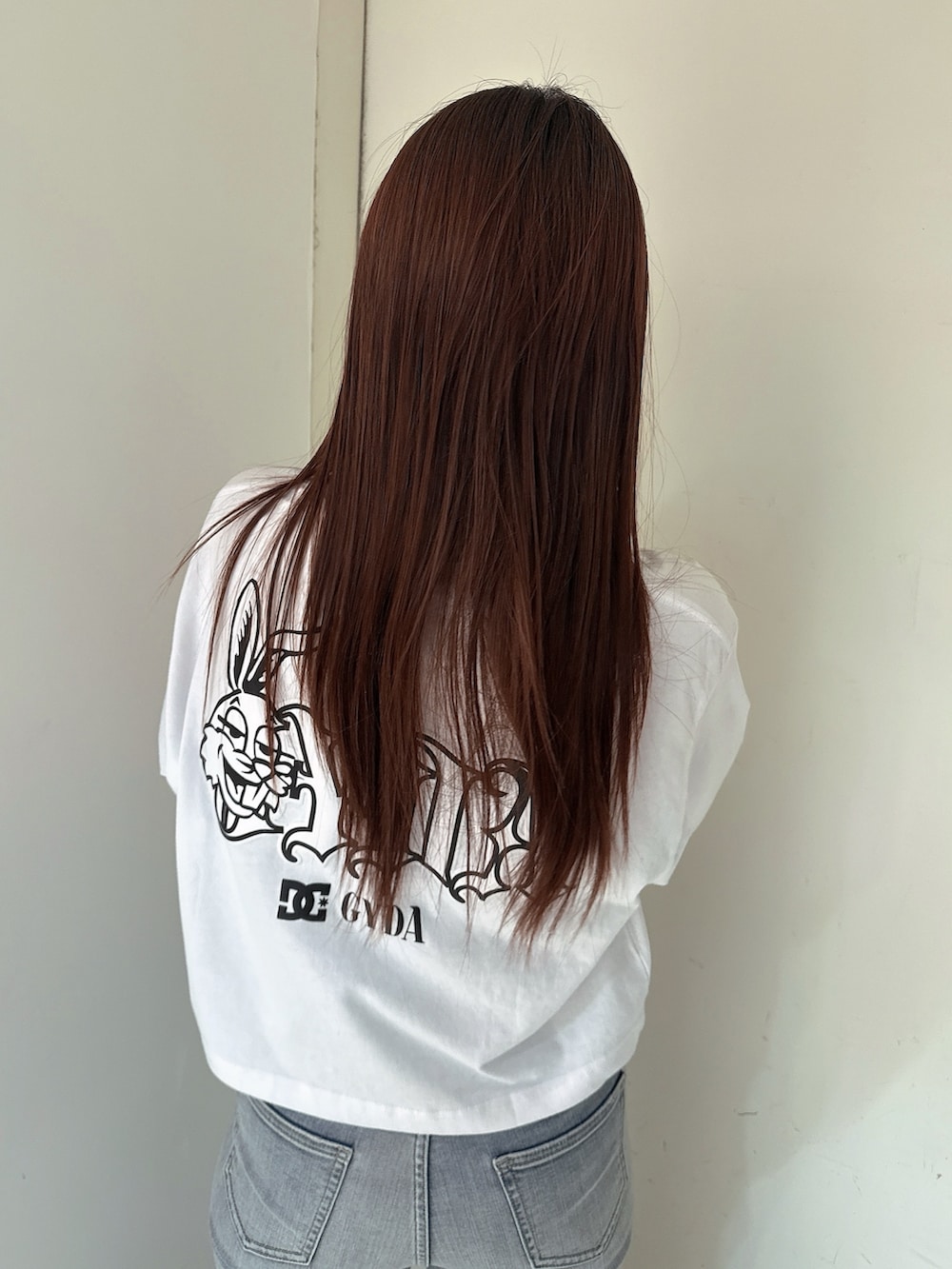 ブルー系のデニムパンツ、ホワイト系のTシャツ/カットソー、ブラック系のサンダルを着用したレディースの春コーディネートの6枚目の写真