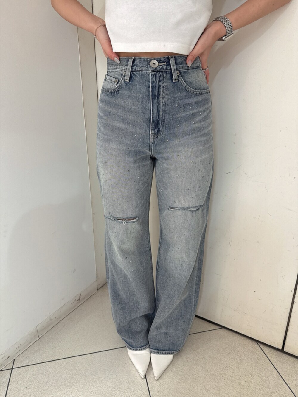 ホワイト系のサンダル、ホワイト系のTシャツ/カットソー、ブルー系のデニムパンツを着用したレディースの春コーディネートの8枚目の写真