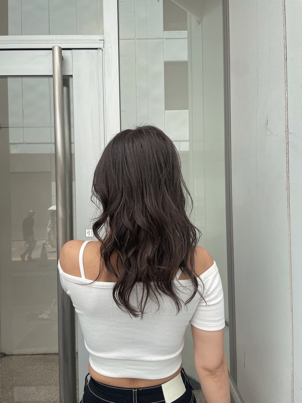 ホワイト系のTシャツ/カットソー、ホワイト系のハンドバッグ、ブラック系のデニムパンツを着用したレディースの夏コーディネートの4枚目の写真