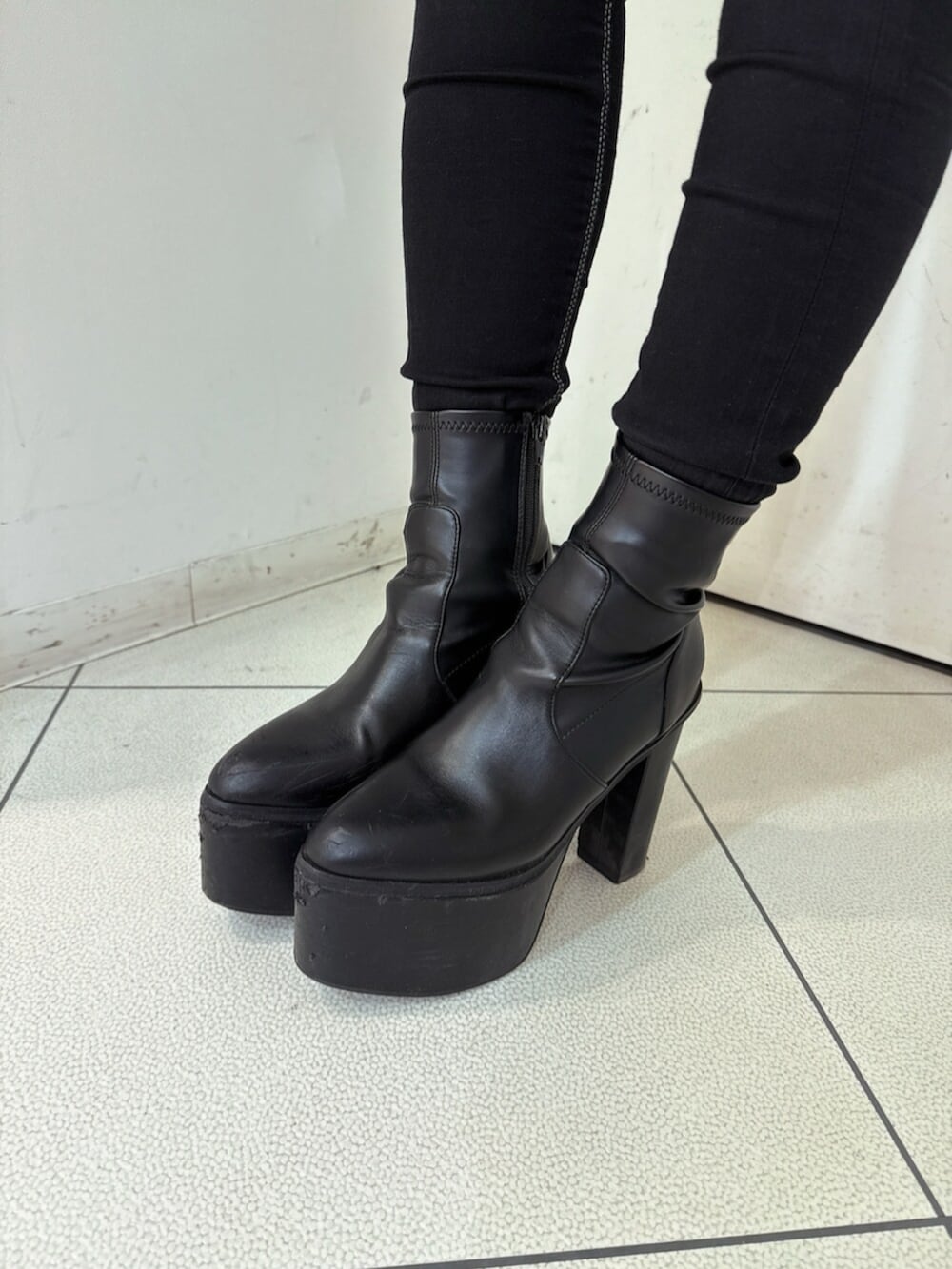 ブラック系のデニムパンツ、ブラック系のブーツ、ホワイト系のニット/セーターを着用したレディースの冬コーディネートの9枚目の写真