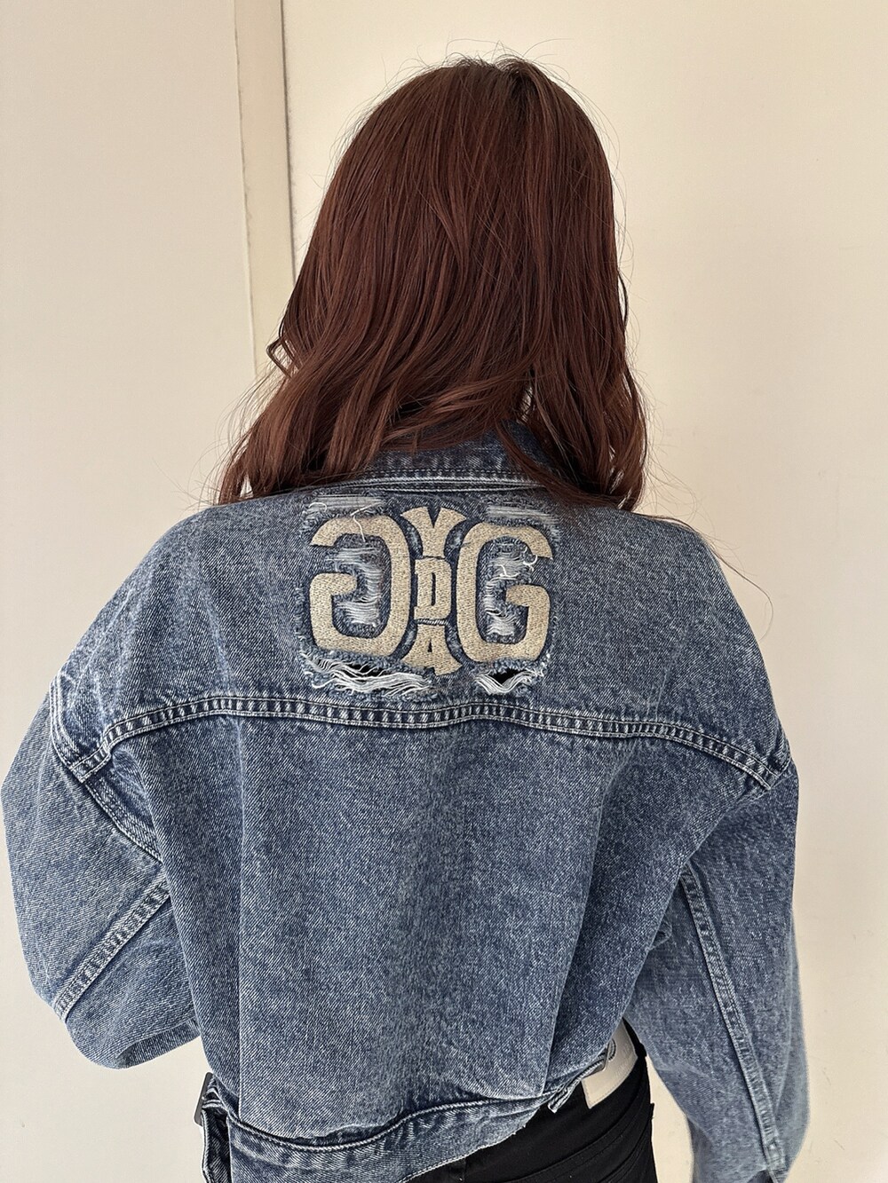 ブラック系のTシャツ/カットソー、ブルー系のデニムジャケット、ブラック系のデニムパンツを着用したレディースの春コーディネートの6枚目の写真