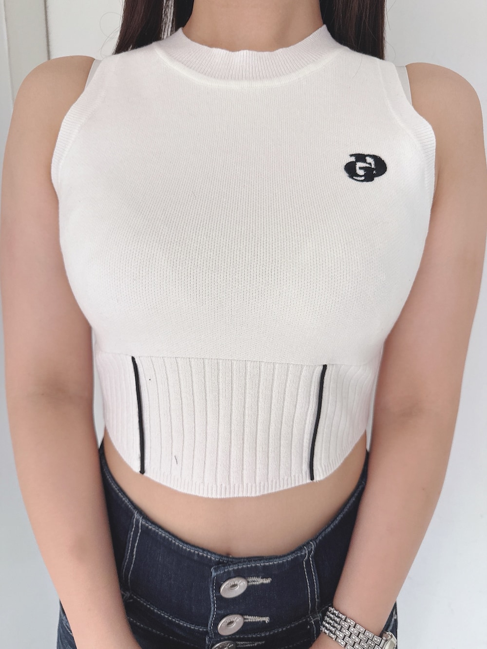 ホワイト系のニット/セーター、ブルー系のデニムパンツ、ホワイト系のサンダルを着用したレディースの夏コーディネートの7枚目の写真