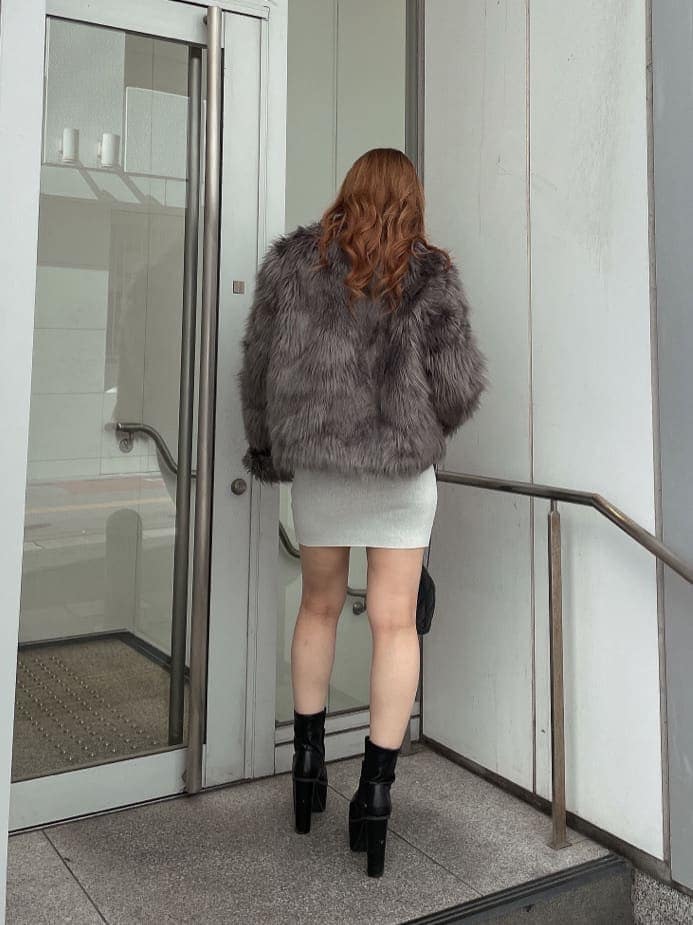 ブラック系のブーツ、グレー系のライダースジャケット、ホワイト系のワンピースを着用したレディースの秋コーディネートの4枚目の写真