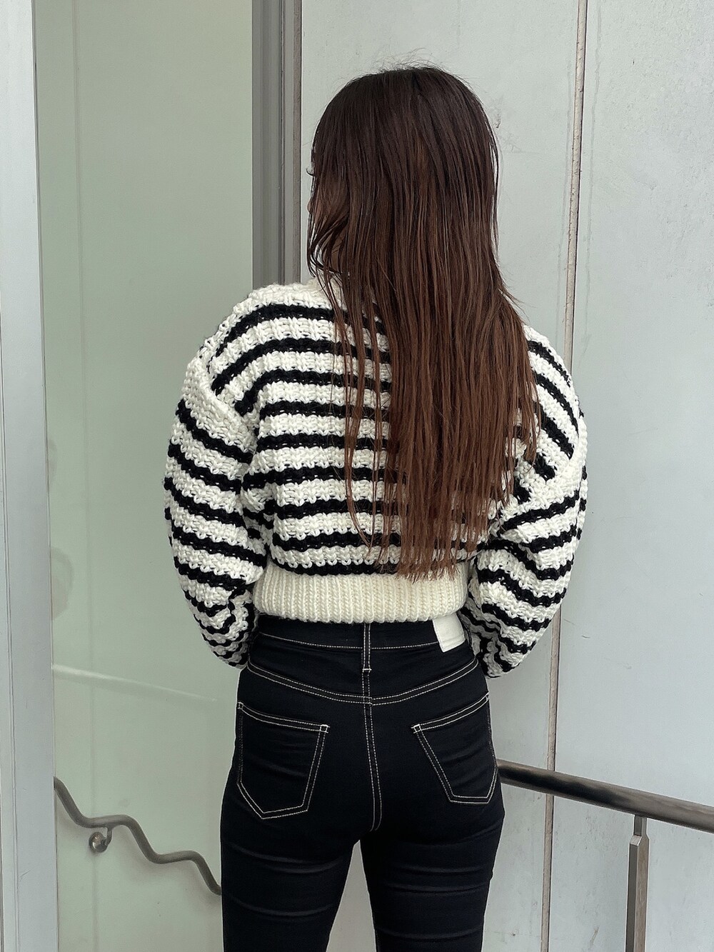 その他のカーディガン/ボレロ、ブラック系のデニムパンツ、ブラック系のブーツを着用したレディースの秋コーディネートの6枚目の写真