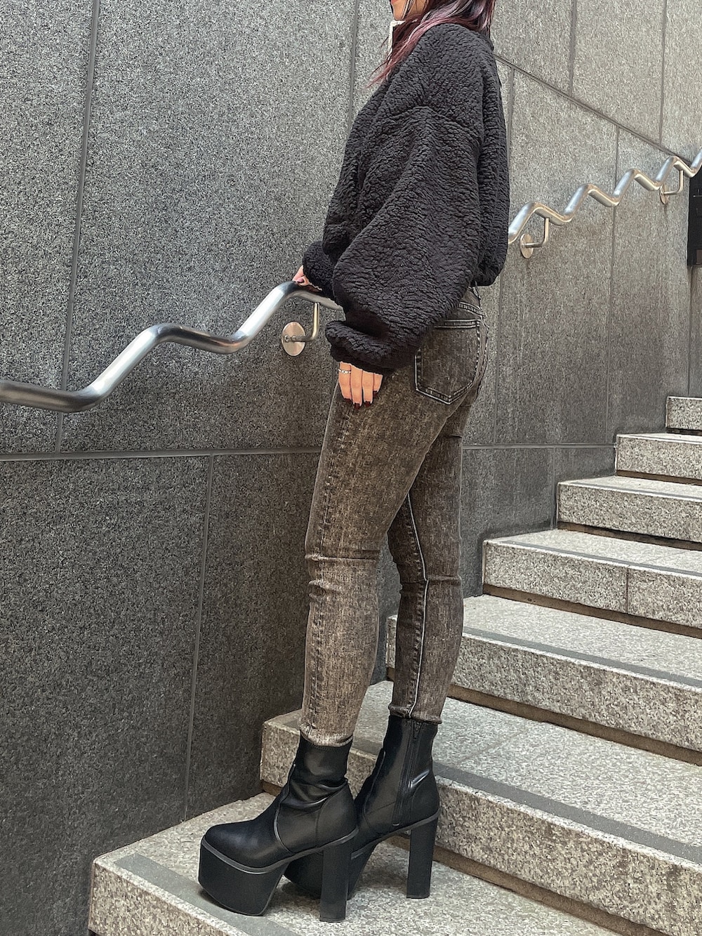 ブラック系のパーカー、ブラック系のデニムパンツ、ブラック系のブーツを着用したレディースの秋コーディネートの2枚目の写真