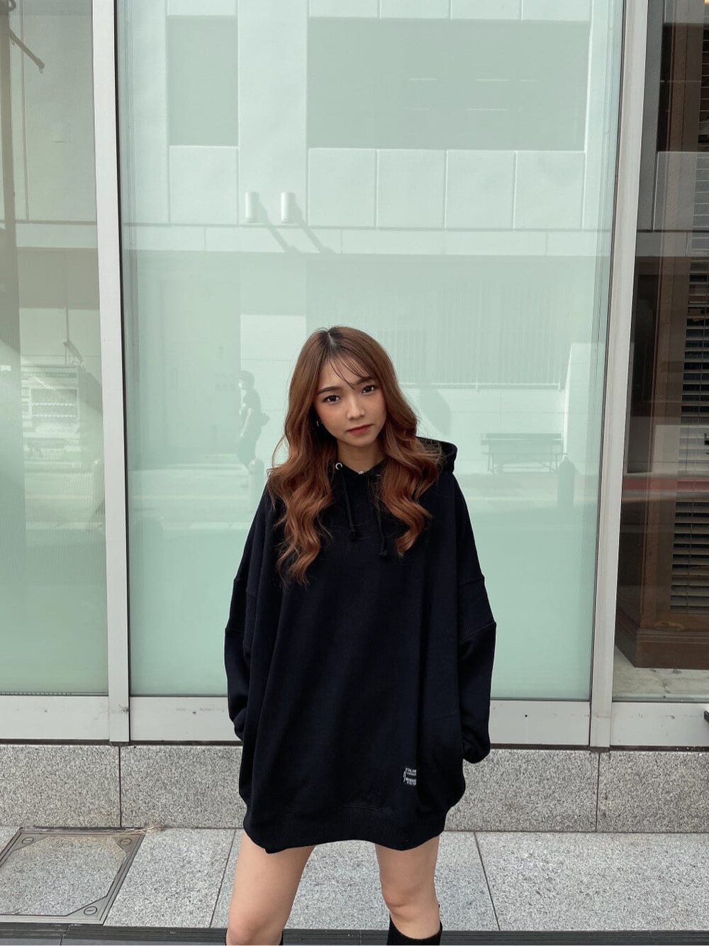 ブラック系のパーカー、ブラック系のデニムパンツ、ブラック系のブーツを着用したレディースの秋コーディネートの5枚目の写真