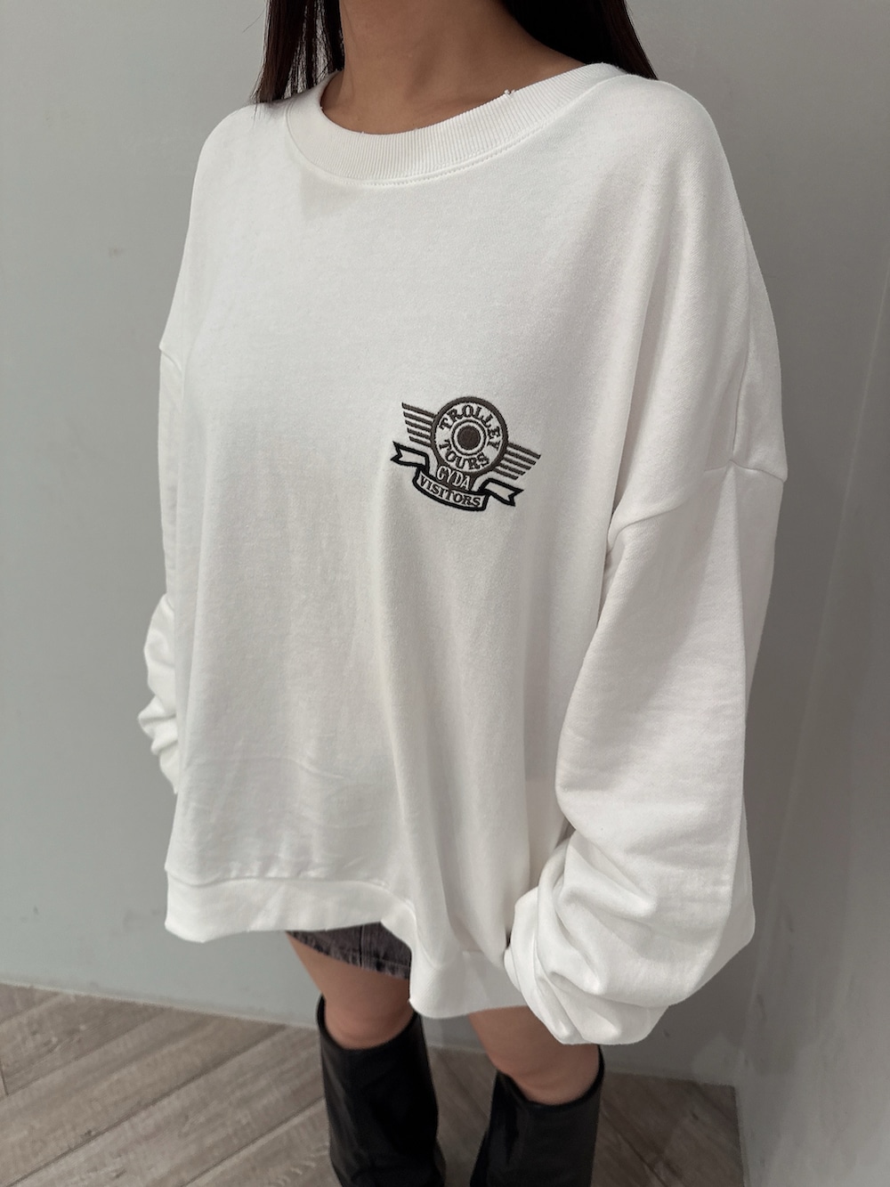 ホワイト系のスウェット、ブラック系のブーツを着用したレディースの夏コーディネートの7枚目の写真