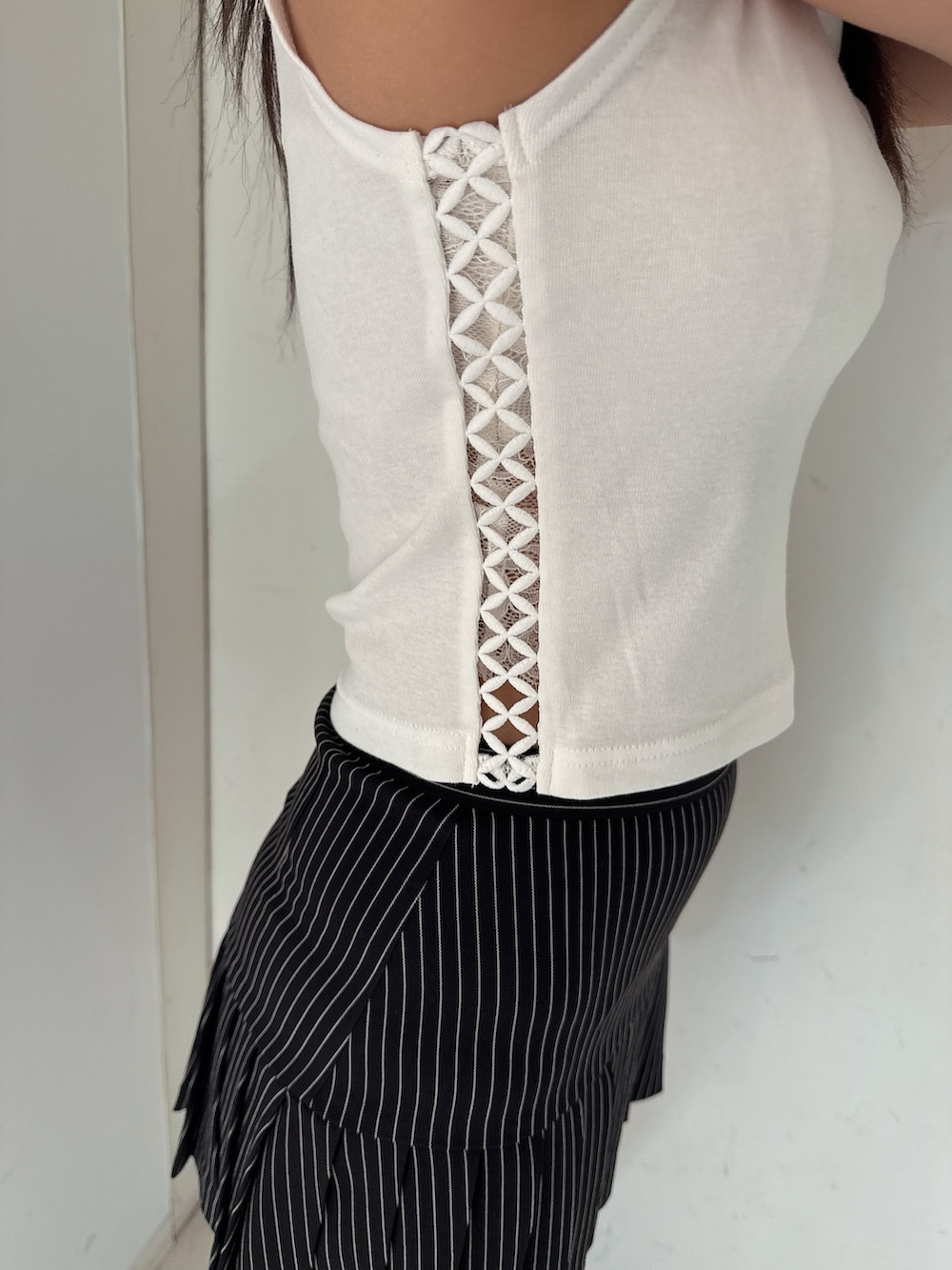 ブラック系のスカート、ホワイト系のタンクトップ、ブラック系のサンダルを着用したレディースの夏コーディネートの8枚目の写真