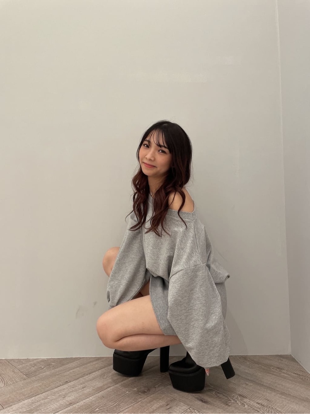 グレー系のワンピース、ブラック系のブーツを着用したレディースの秋コーディネートの3枚目の写真