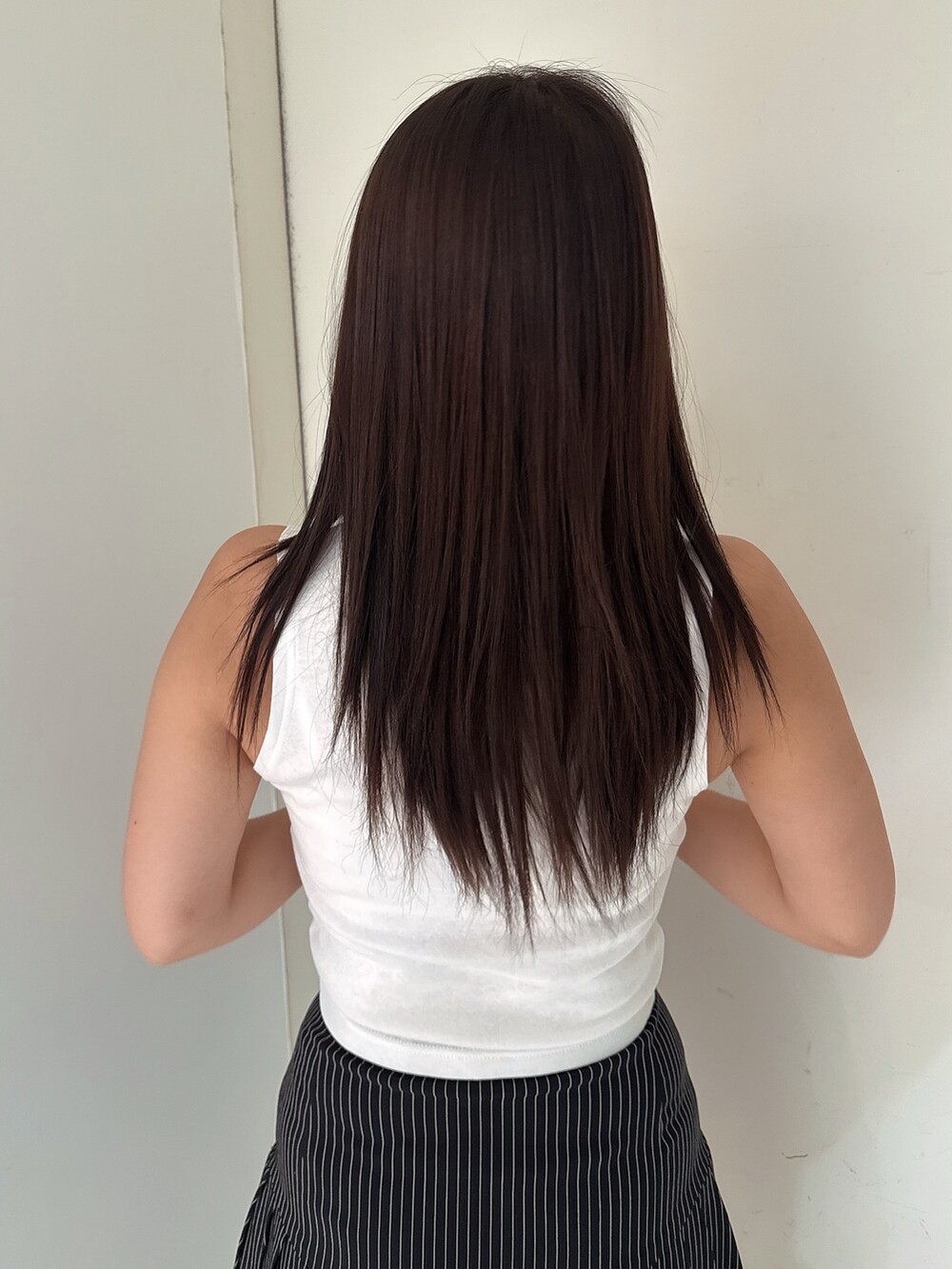 ブラック系のスカート、ホワイト系のタンクトップ、ブラック系のサンダルを着用したレディースの夏コーディネートの6枚目の写真