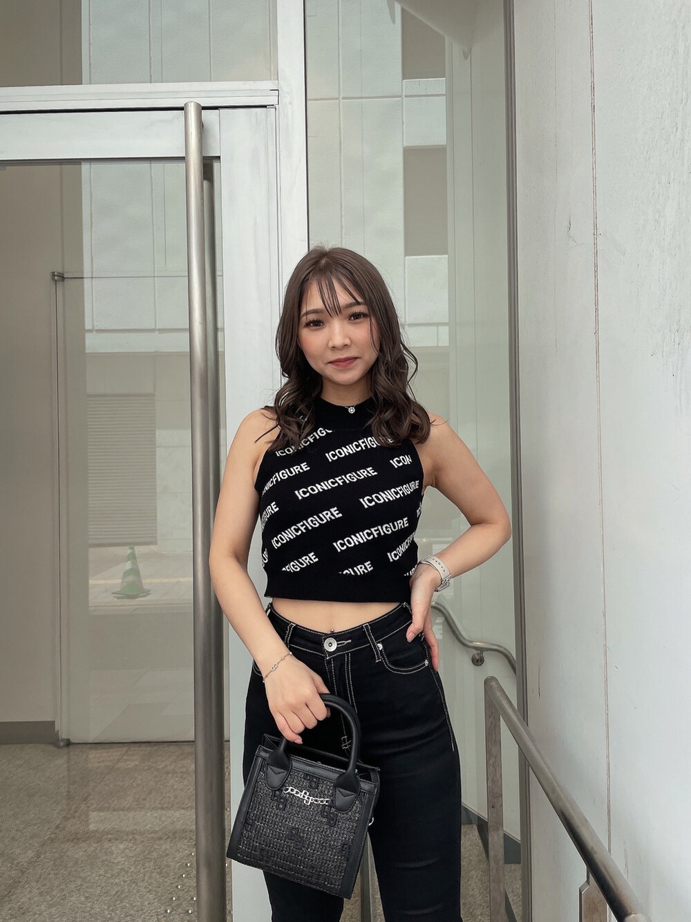 ホワイト系のサンダル、ブラック系のデニムパンツ、ブラック系のハンドバッグを着用したレディースの春コーディネートの7枚目の写真