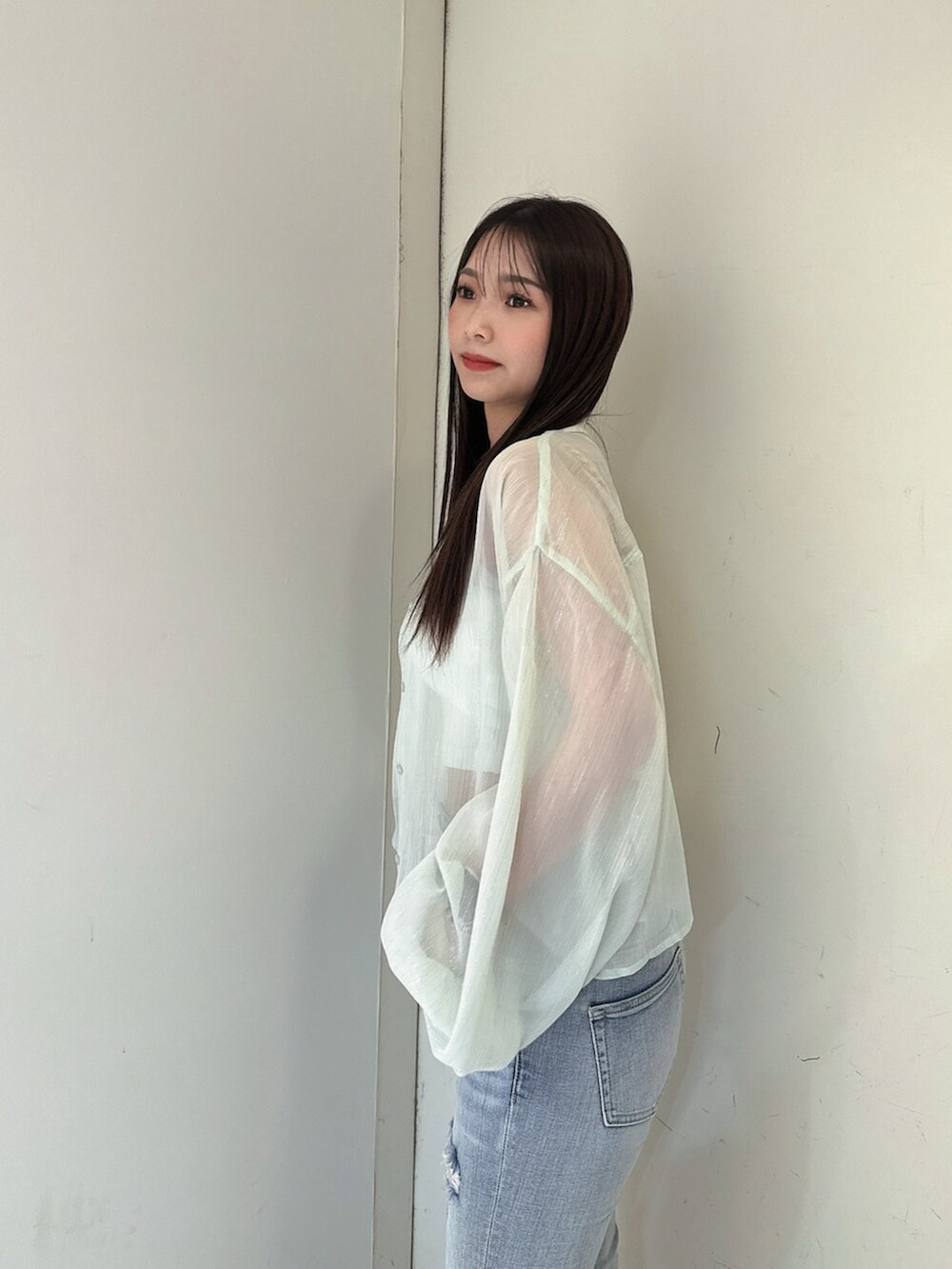 ブルー系のデニムパンツ、グリーン系のシャツ/ブラウス、ホワイト系のチューブトップを着用したレディースの春コーディネートの5枚目の写真