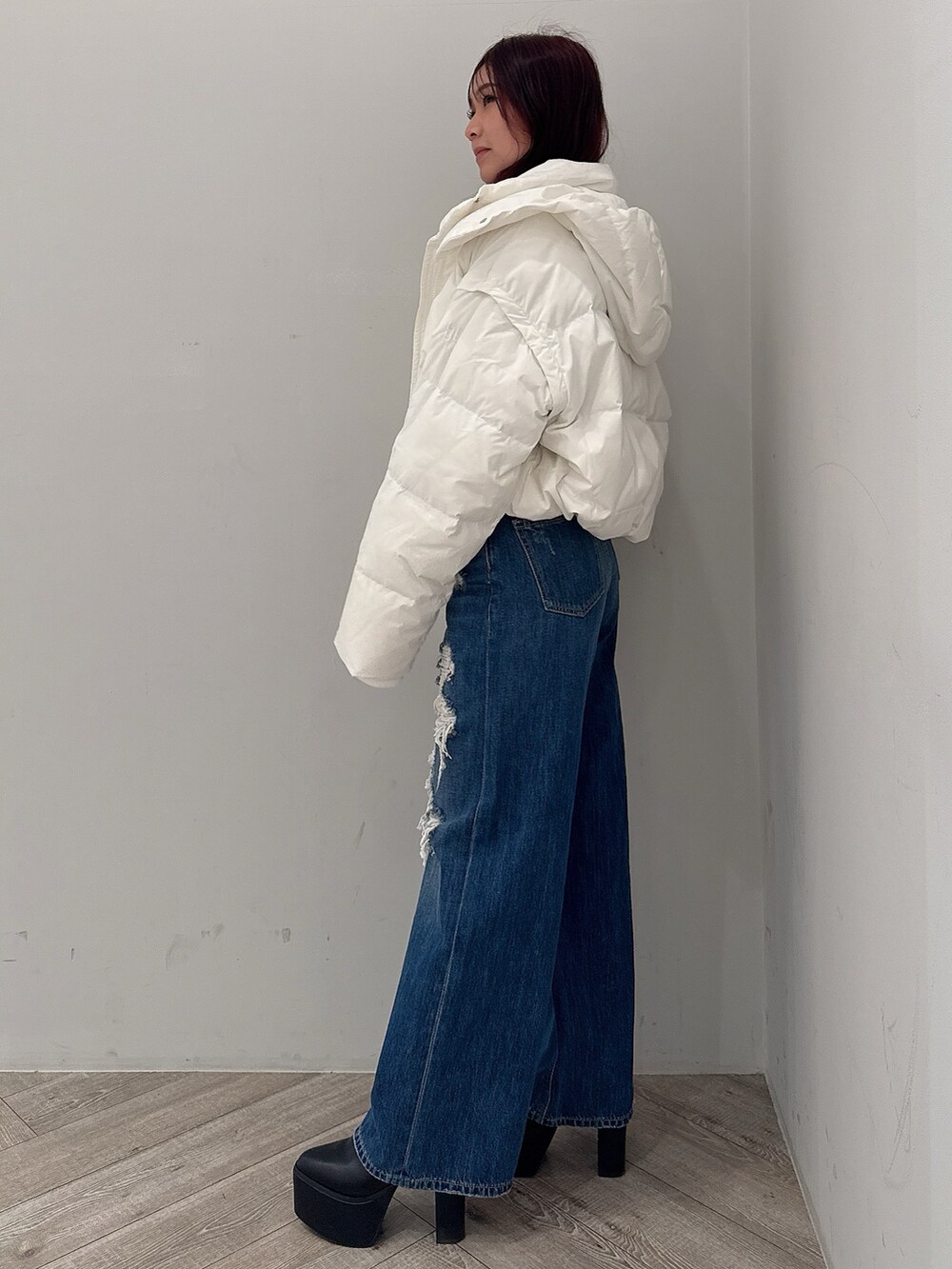 ホワイト系のダウンジャケット/コート、ブルー系のデニムパンツ、ブラック系のブーツを着用したレディースの秋コーディネートの2枚目の写真