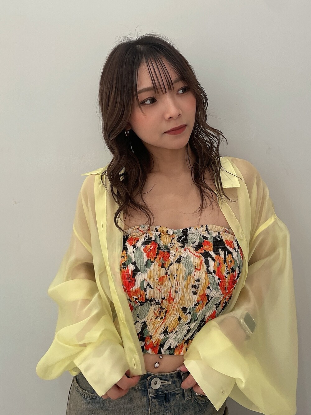 イエロー系のシャツ/ブラウス、ブラック系のチューブトップ、ブルー系のデニムパンツを着用したレディースの春コーディネートの5枚目の写真