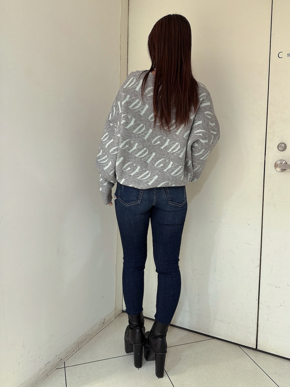 ブラック系のブーツ、ブルー系のデニムパンツ、グレー系のニット/セーターを着用したレディースの冬コーディネートの3枚目の写真