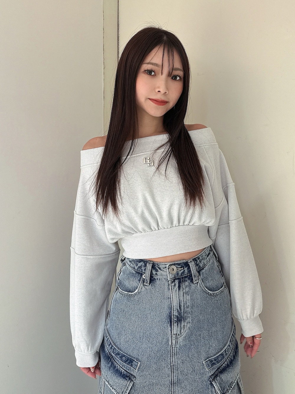 ブルー系のデニムスカート、ホワイト系のTシャツ/カットソー、ブラック系のブーツを着用したレディースの冬コーディネートの4枚目の写真