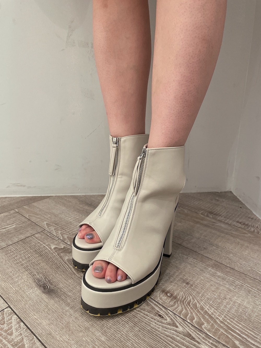 ブラック系のワンピース、ブラック系のハンドバッグ、ホワイト系のブーツを着用したレディースの春コーディネートの8枚目の写真