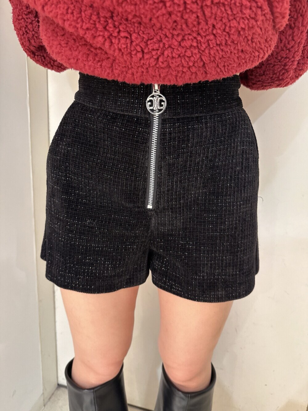ブラック系のブーツ、レッド系のパーカー、ブラック系のその他パンツを着用したレディースの秋コーディネートの8枚目の写真