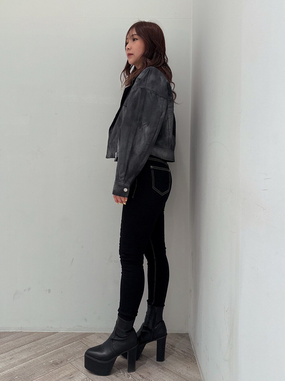 ブラック系のテーラードジャケット、グレー系のニット/セーター、ブラック系のデニムパンツを着用したレディースの冬コーディネートの2枚目の写真