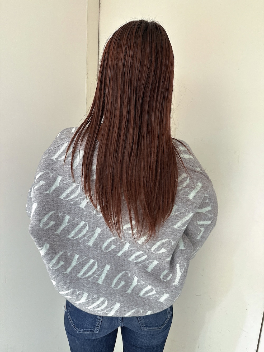 ブラック系のブーツ、ブルー系のデニムパンツ、グレー系のニット/セーターを着用したレディースの冬コーディネートの6枚目の写真