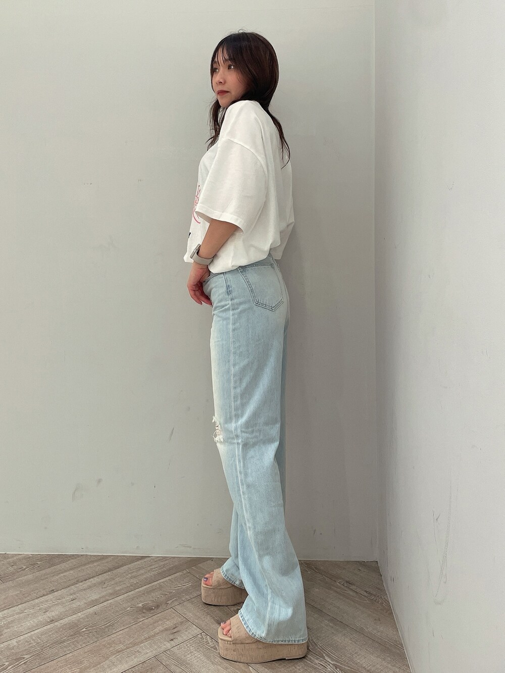 ホワイト系のTシャツ/カットソー、ブルー系のデニムパンツ、ホワイト系のサンダルを着用したレディースの春コーディネートの2枚目の写真