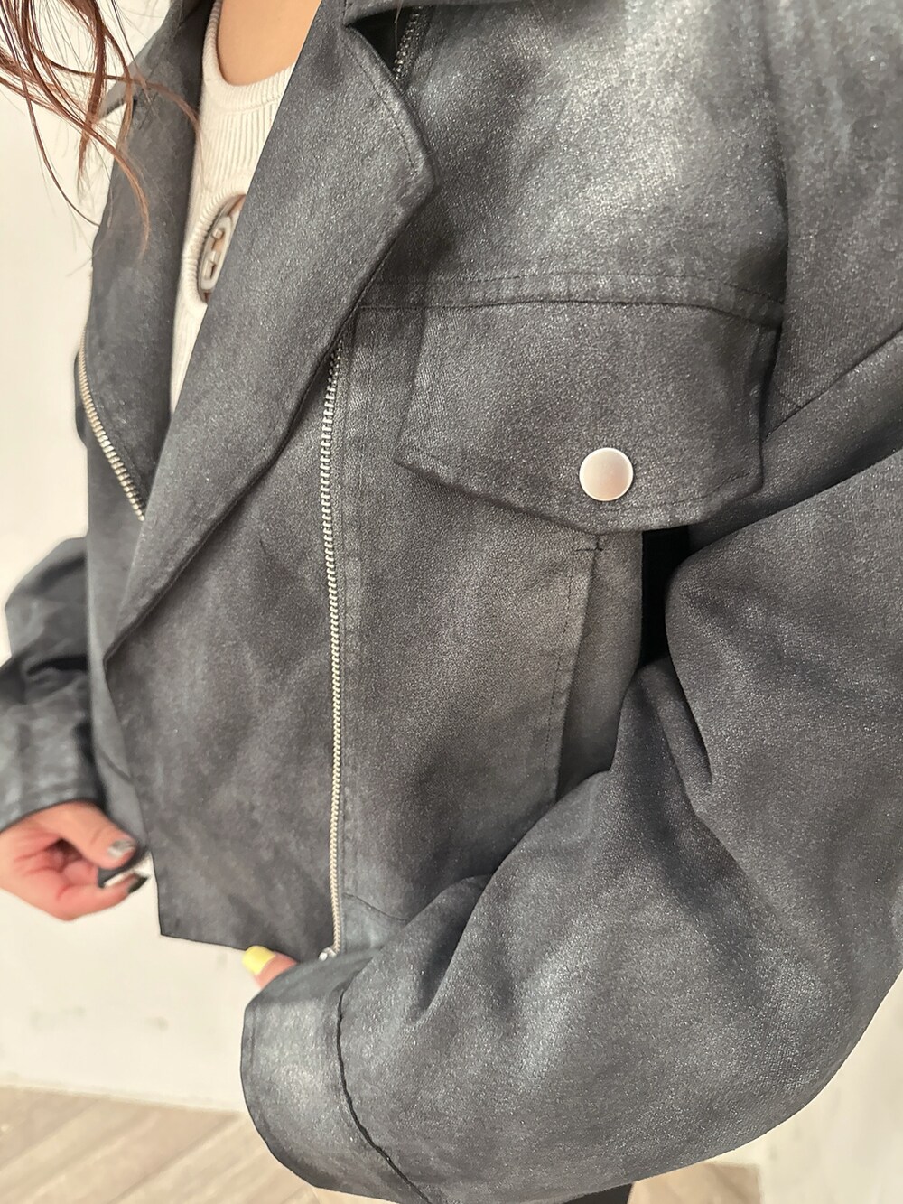 ブラック系のテーラードジャケット、グレー系のニット/セーター、ブラック系のデニムパンツを着用したレディースの冬コーディネートの7枚目の写真