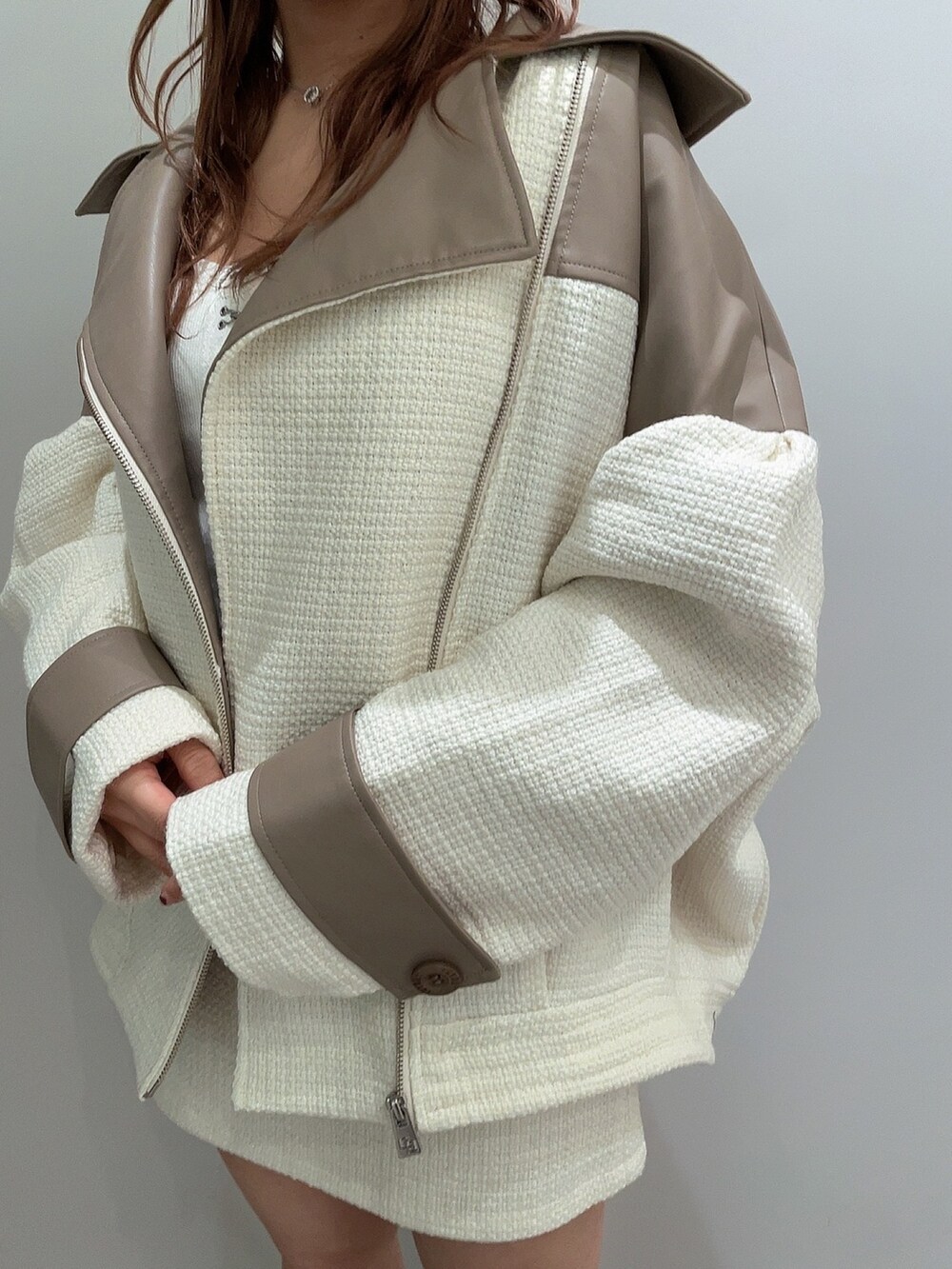 ホワイト系のキャミソール、ホワイト系のライダースジャケット、ホワイト系のスカートを着用したレディースの春コーディネートの6枚目の写真